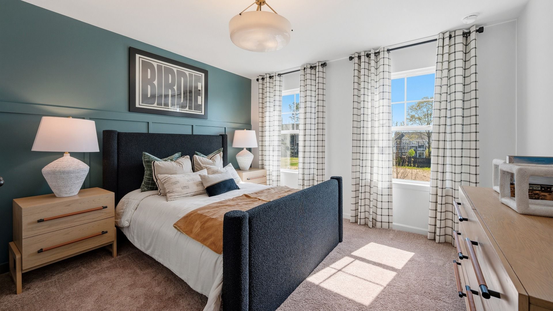 Secondary bedroom with bright natural lighting from windows, carpet, and closet