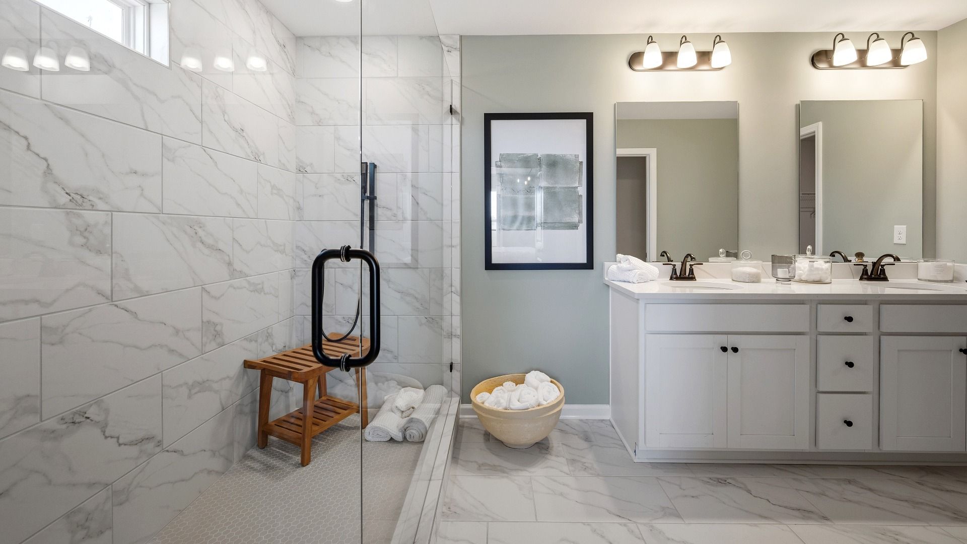 Spacious primary suite with large glass enclosed shower and dual vanity