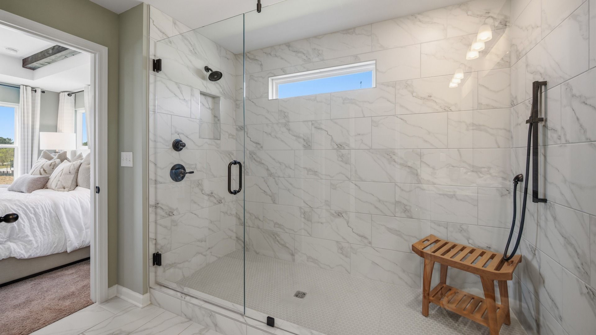 Spacious primary suite with large glass enclosed shower with shower window