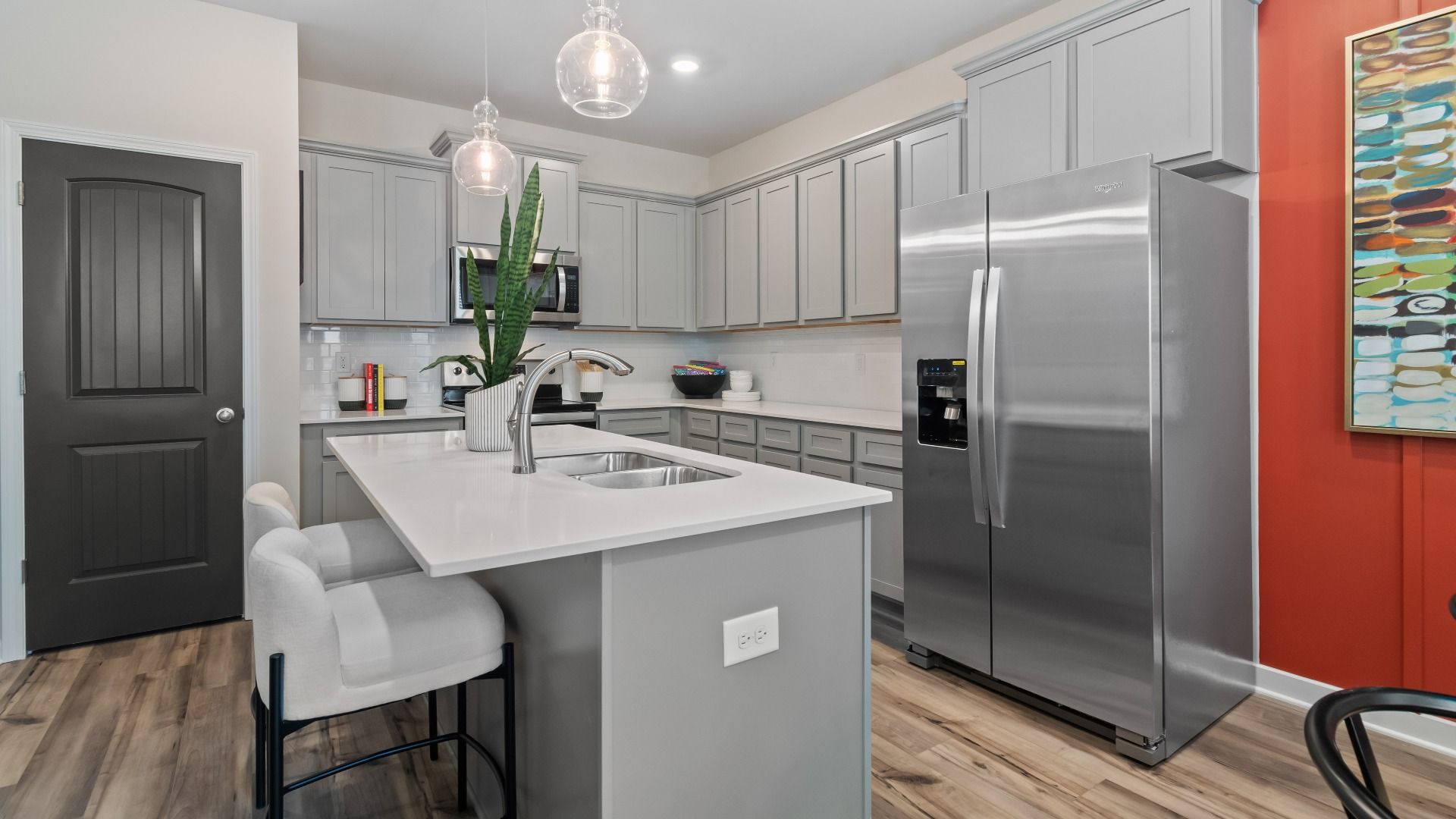 Spacious kitchen with tile backsplash, quartz countertops, and pendant lighting