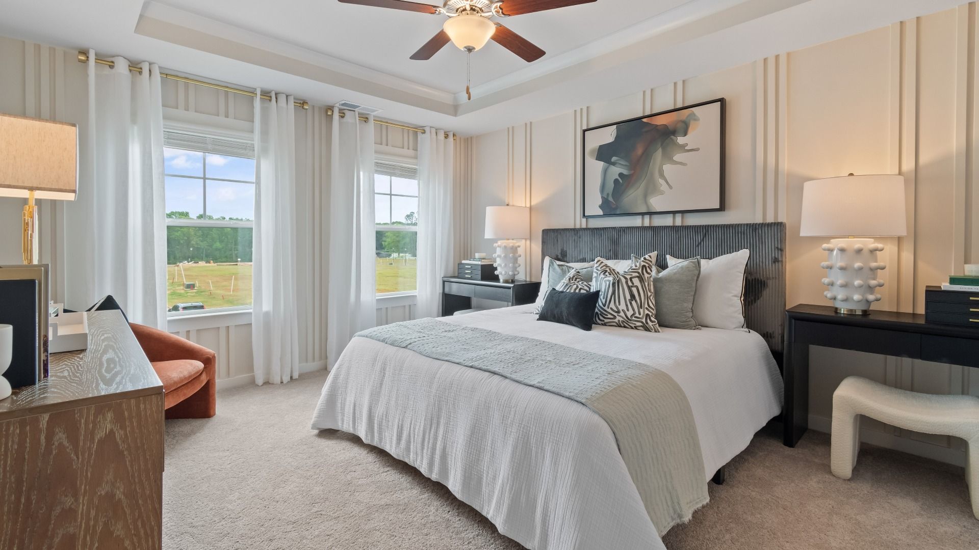 Spacious primary bedroom with accent walls and tray ceiling