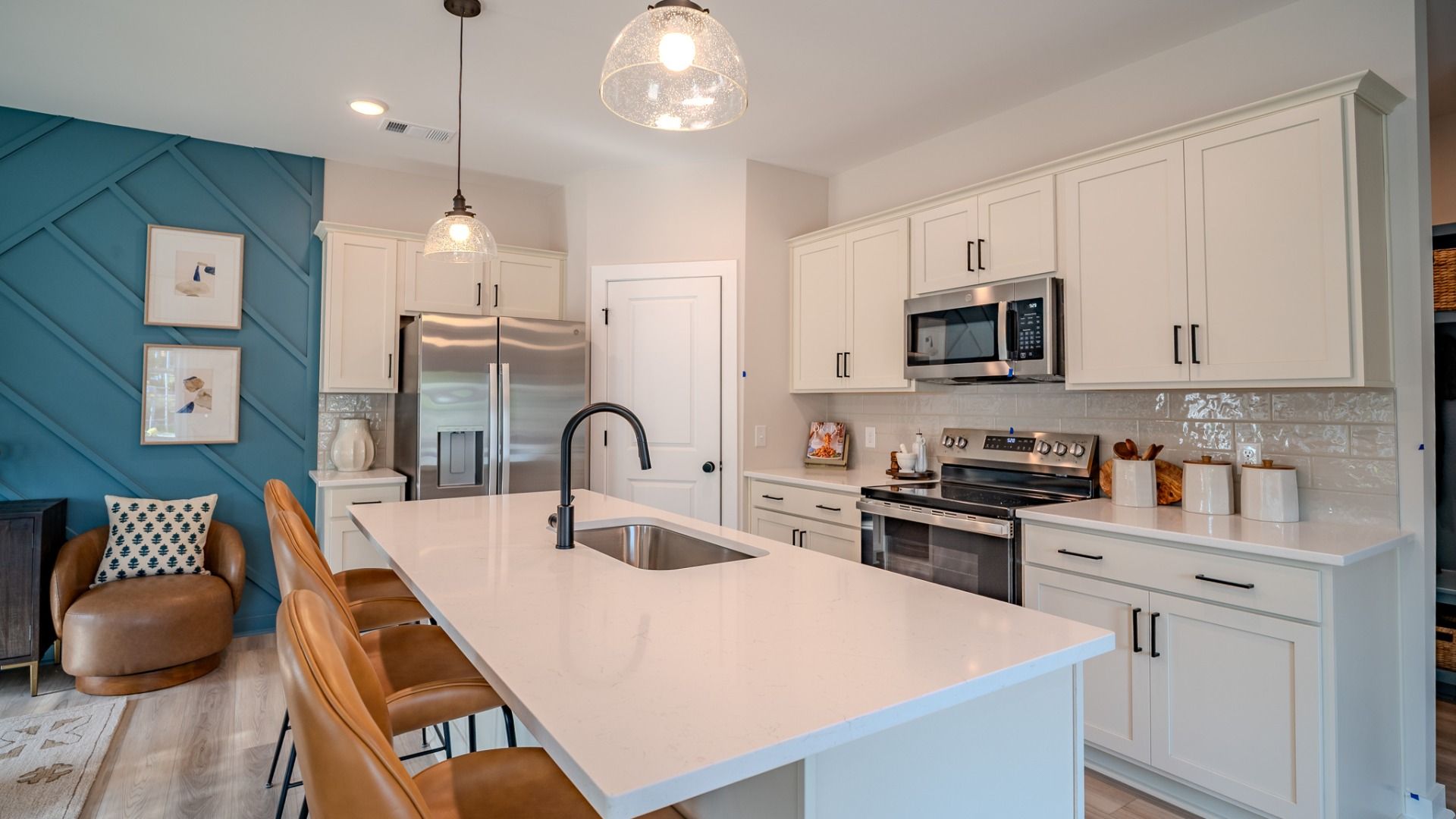 Kitchen with tile backsplash, quartz countertops, and pendant lighting