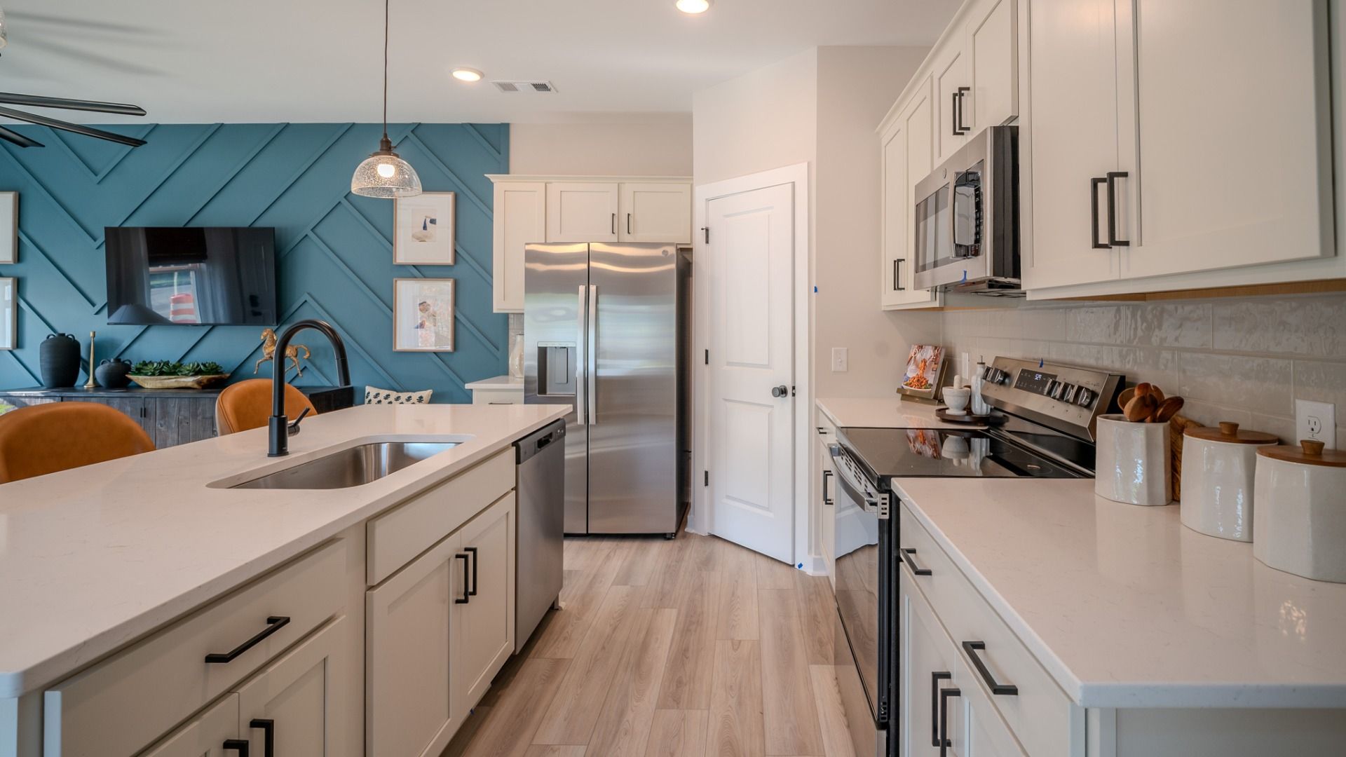 Kitchen with tile backsplash, quartz countertops, and pendant lighting