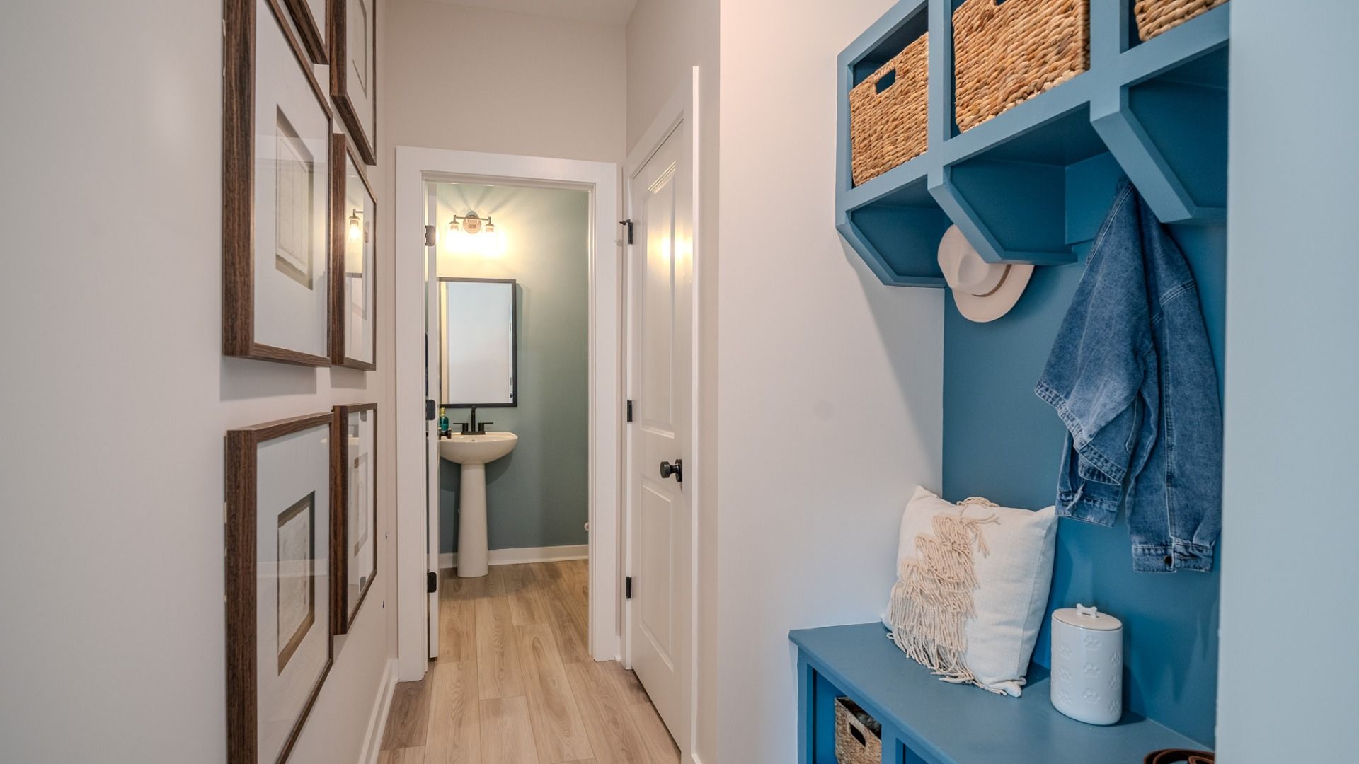 Hallway with blue drop-zone and powder room