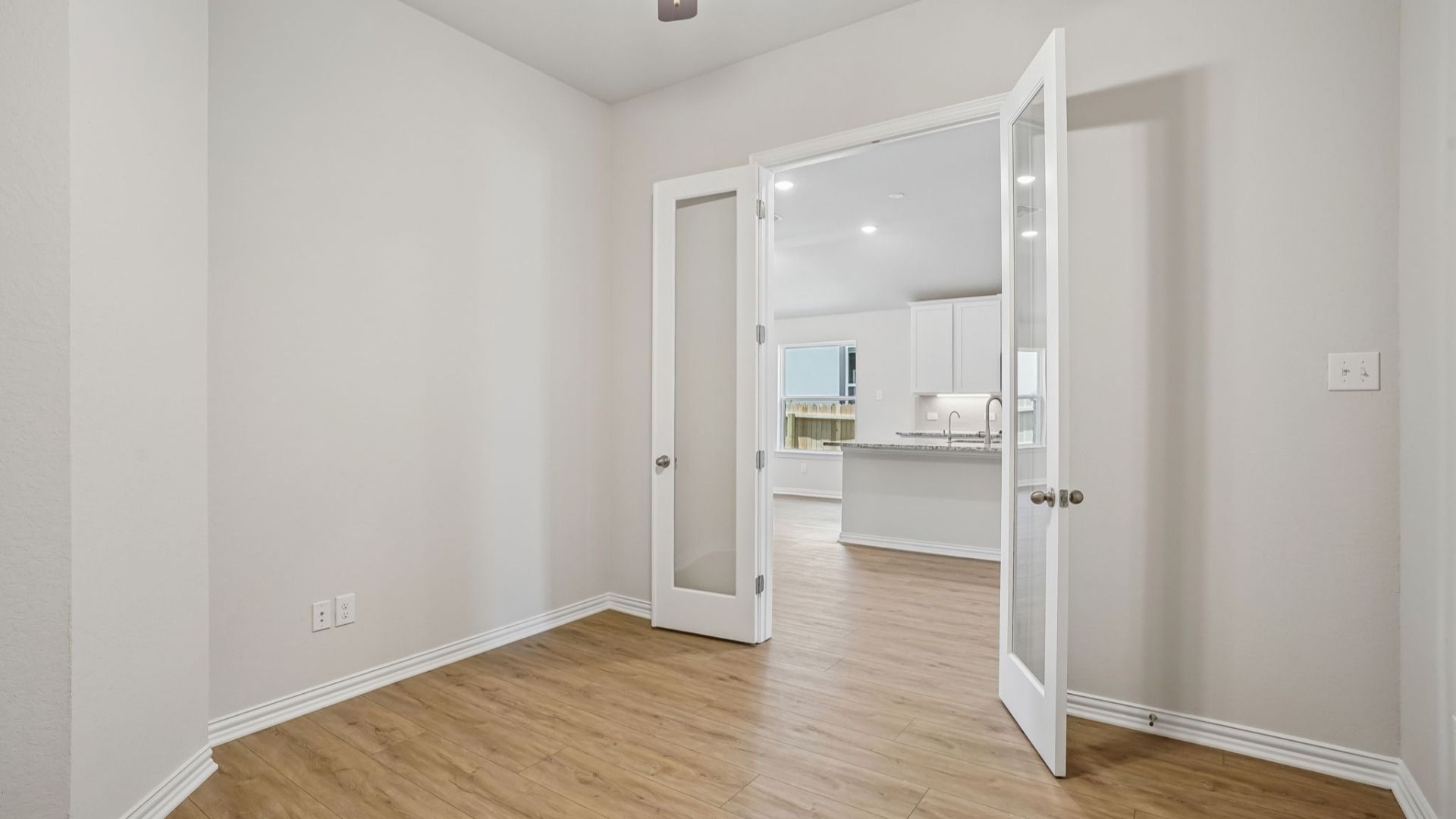 Dedicated office space with glass doors located near the kitchen.