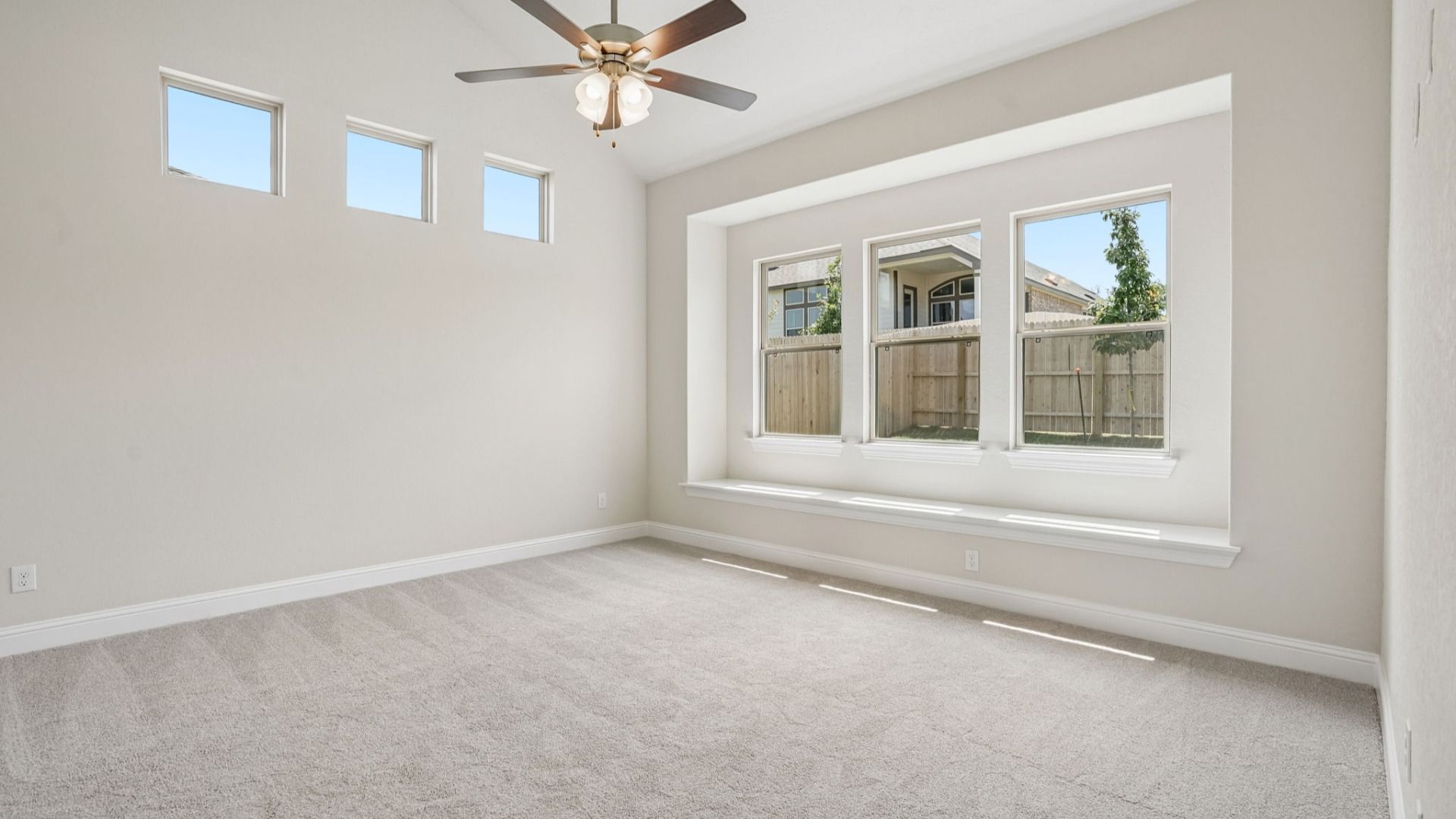 Spacious owner's suite with a window seat, high ceilings, and abundant natural light.