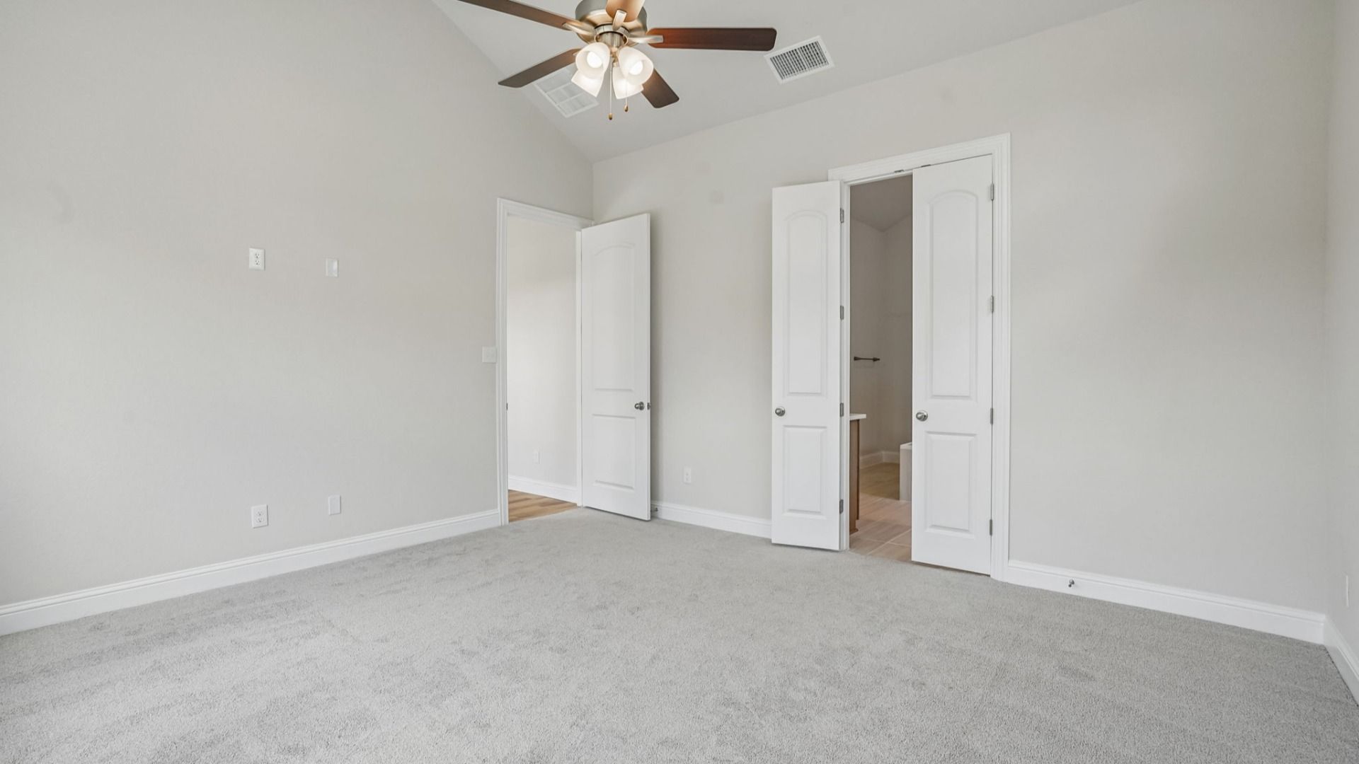 Spacious owner's suite with a window seat, high ceilings, and abundant natural light.