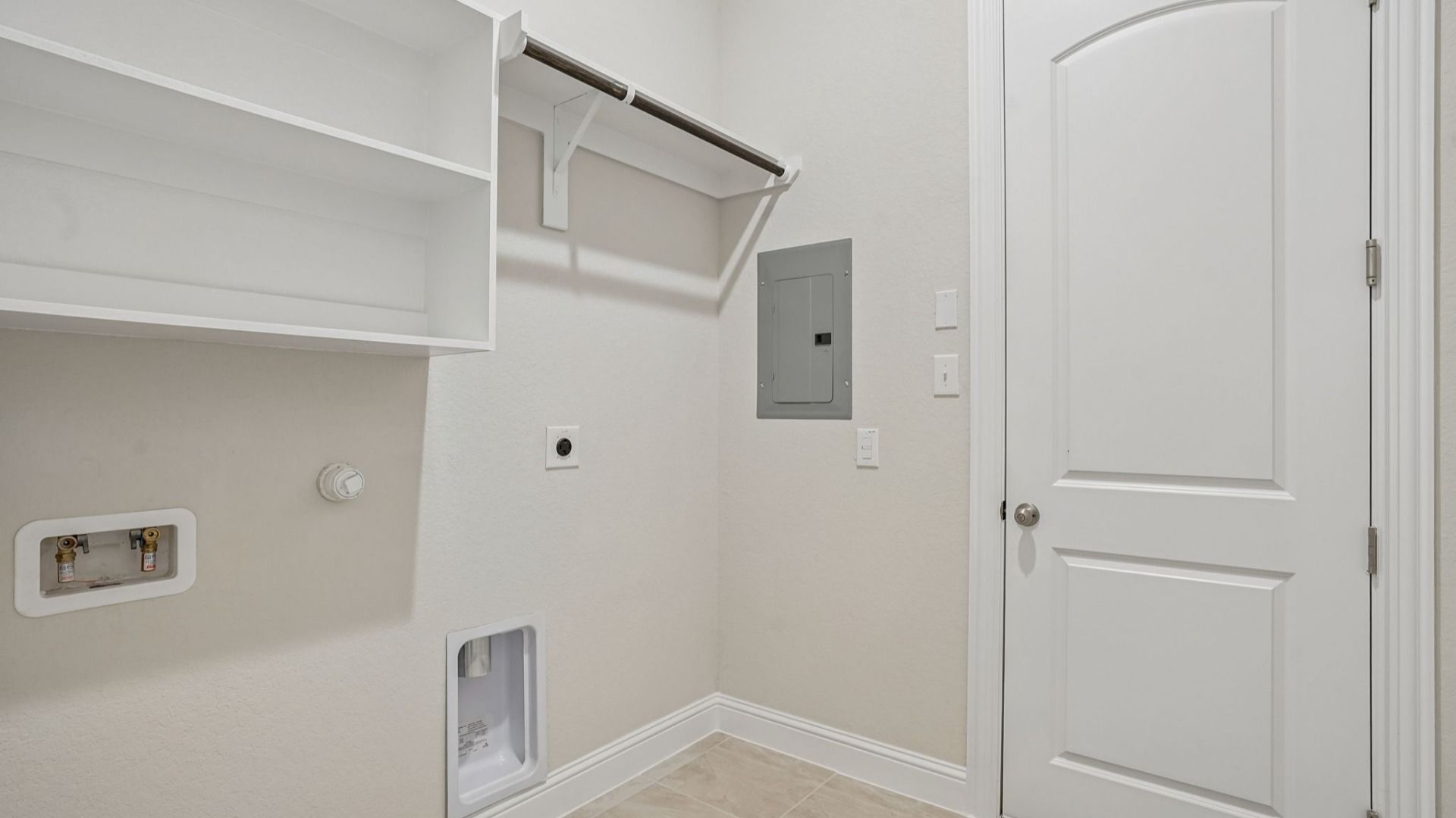 Full Sized Utility Room with Built-In Shelving and Wooden Clothing Rod