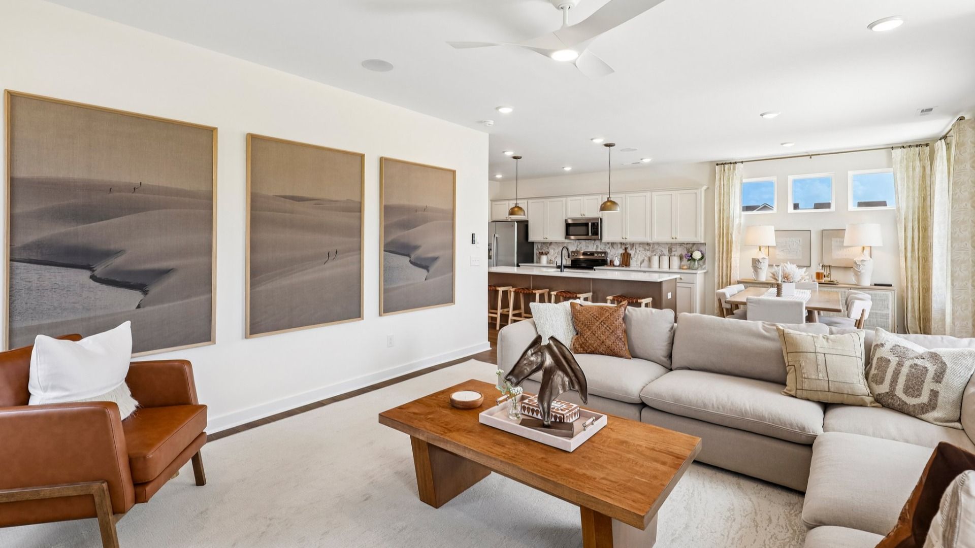Gathering room with ceiling fan, hard surface flooring, fireplace, and natural lighting from windows