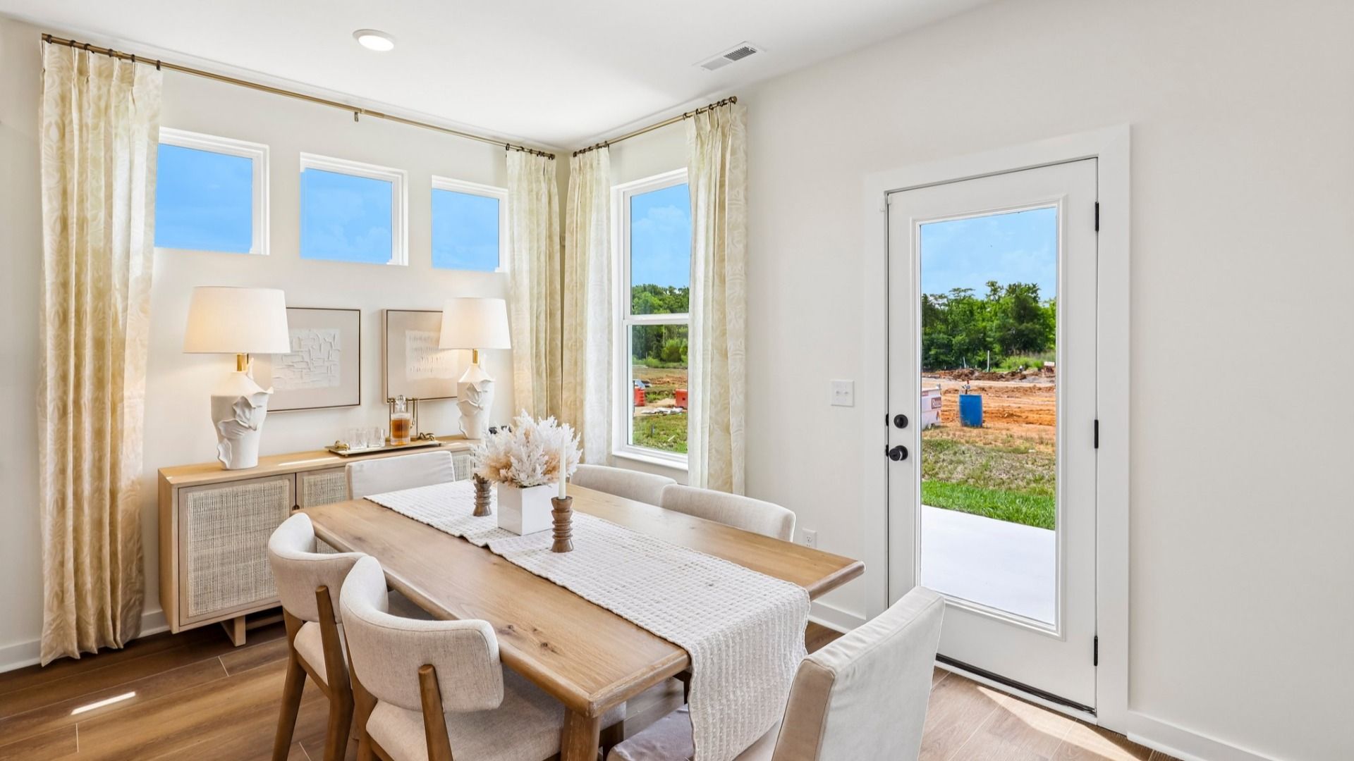 Dining area with natural lighting from windows and access to rear entrance