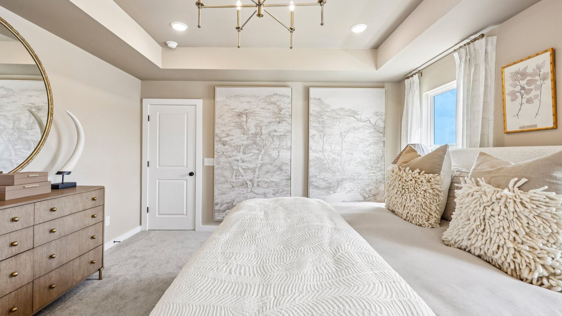 Primary suite with tray ceiling, windows, and carpet