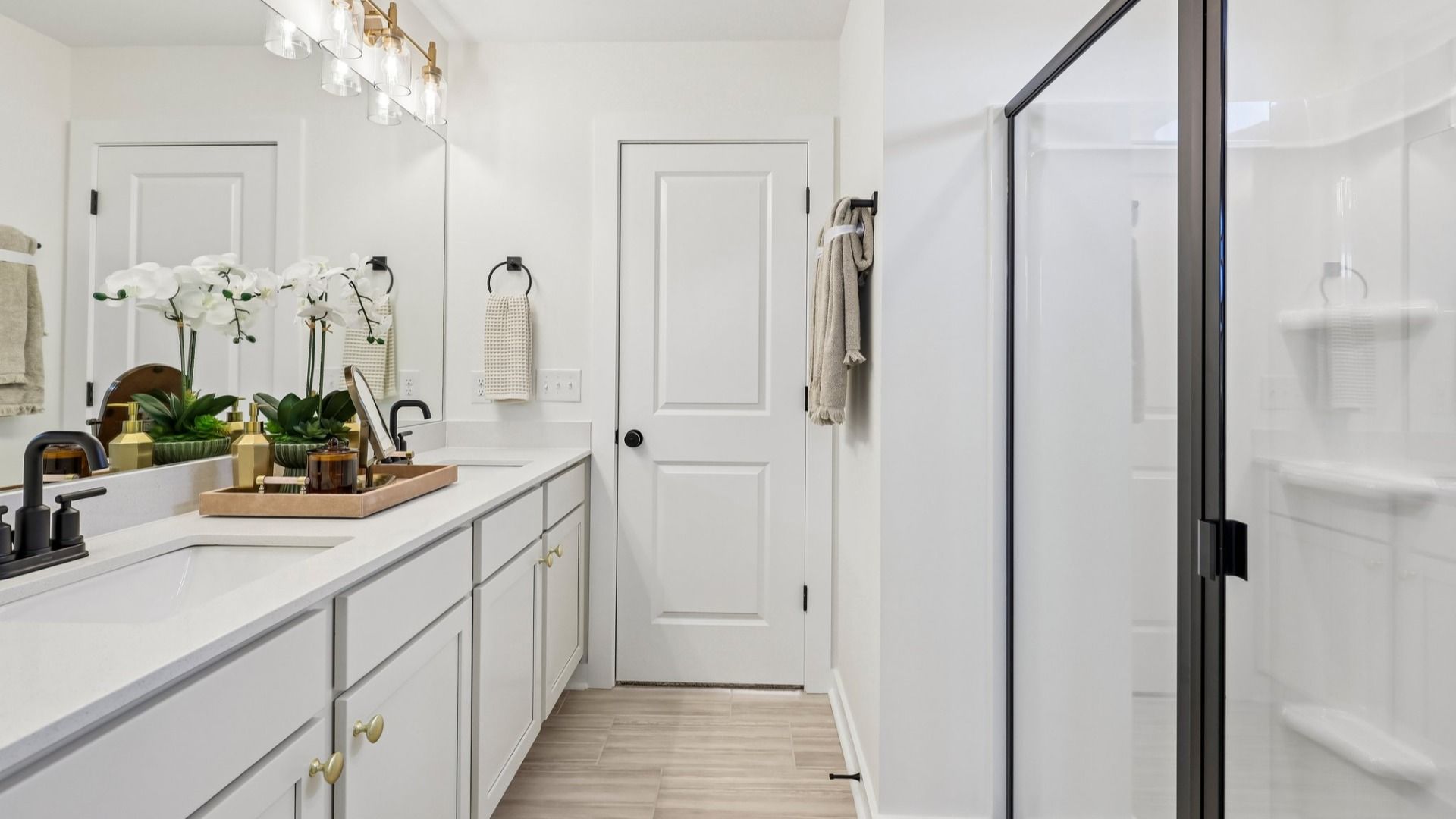 Primary bathroom with dual vanity and glass enclosed