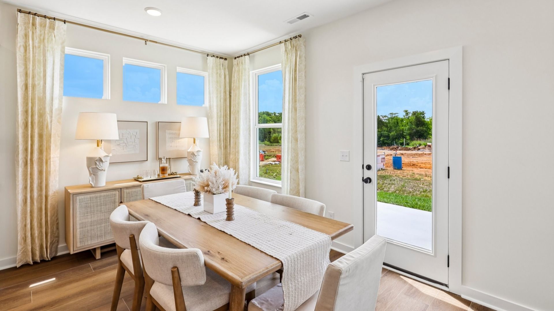 Dining area with natural lighting from windows and access to rear entrance