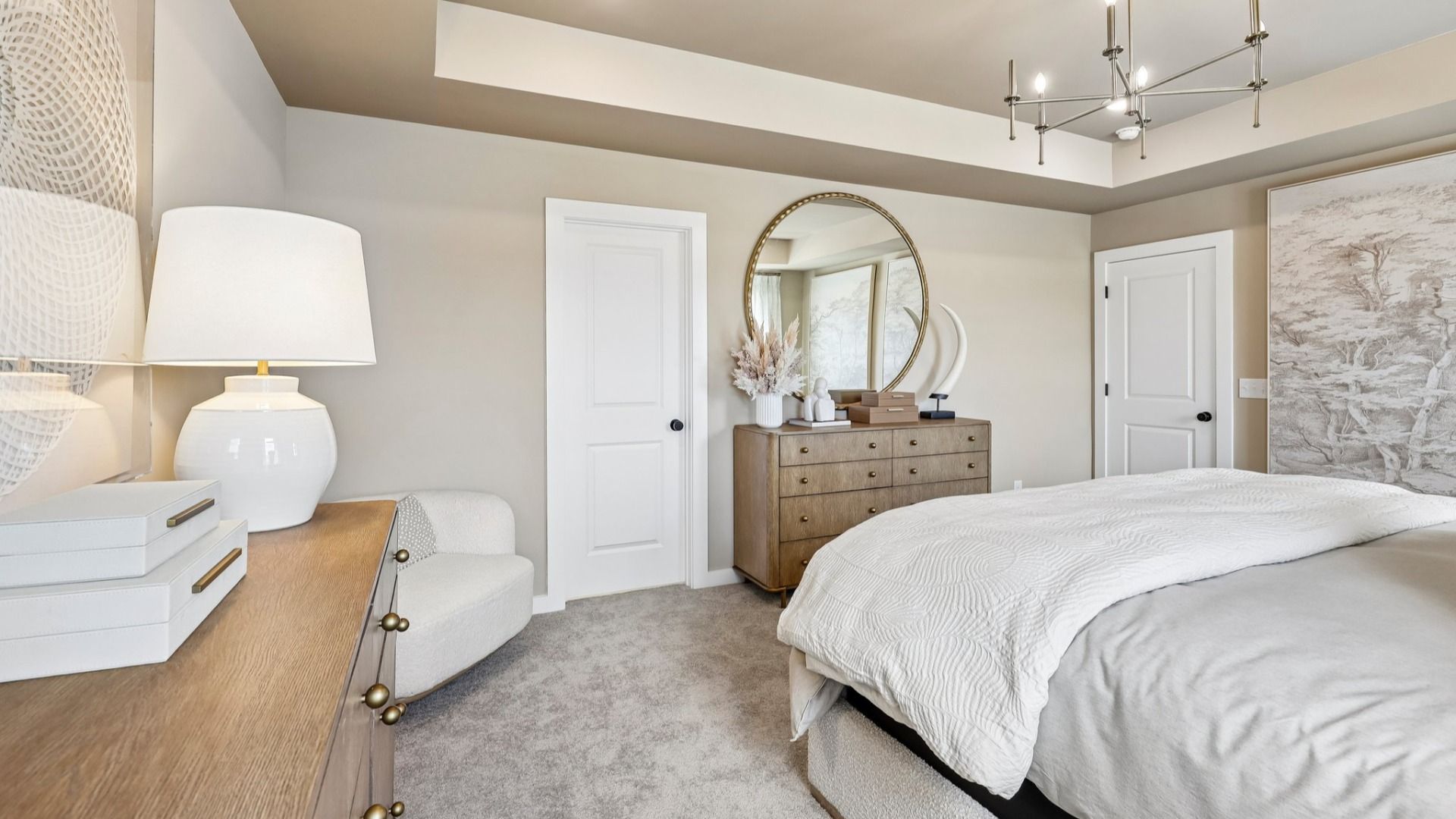 Primary suite with tray ceiling, windows, and carpet