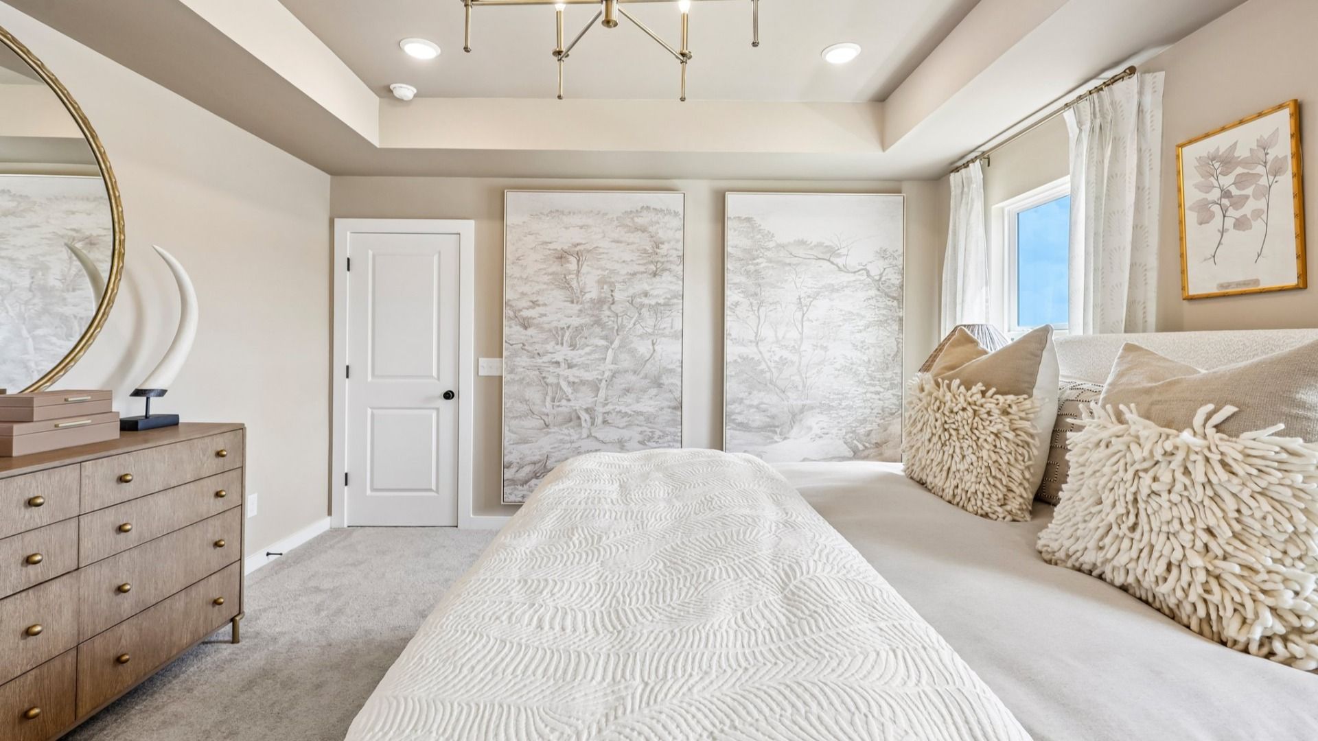 Primary suite with tray ceiling, windows, and carpet