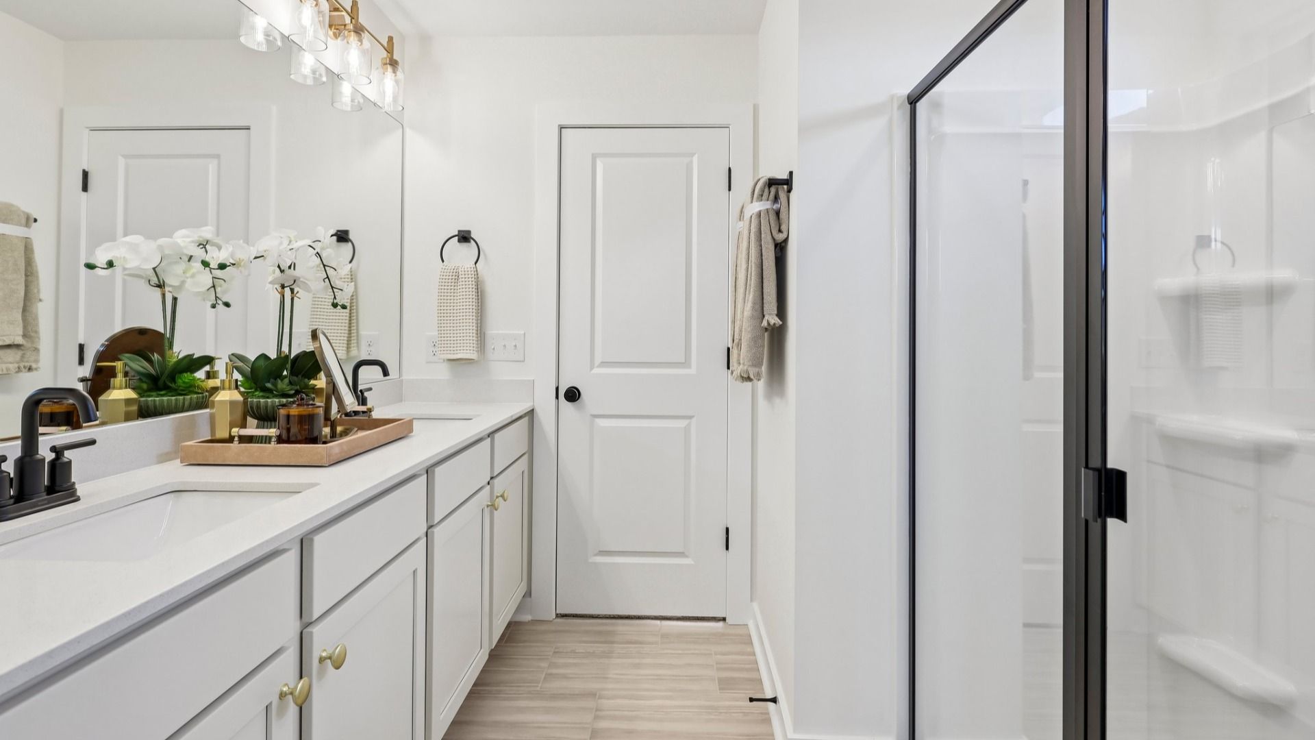 Primary bathroom with dual vanity and glass enclosed shower