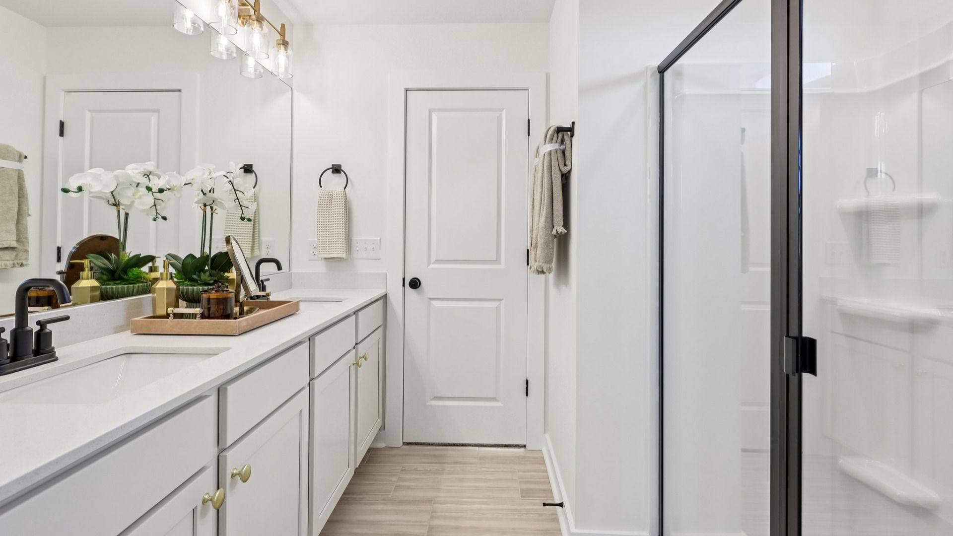 Primary bathroom with dual vanity and glass enclosed