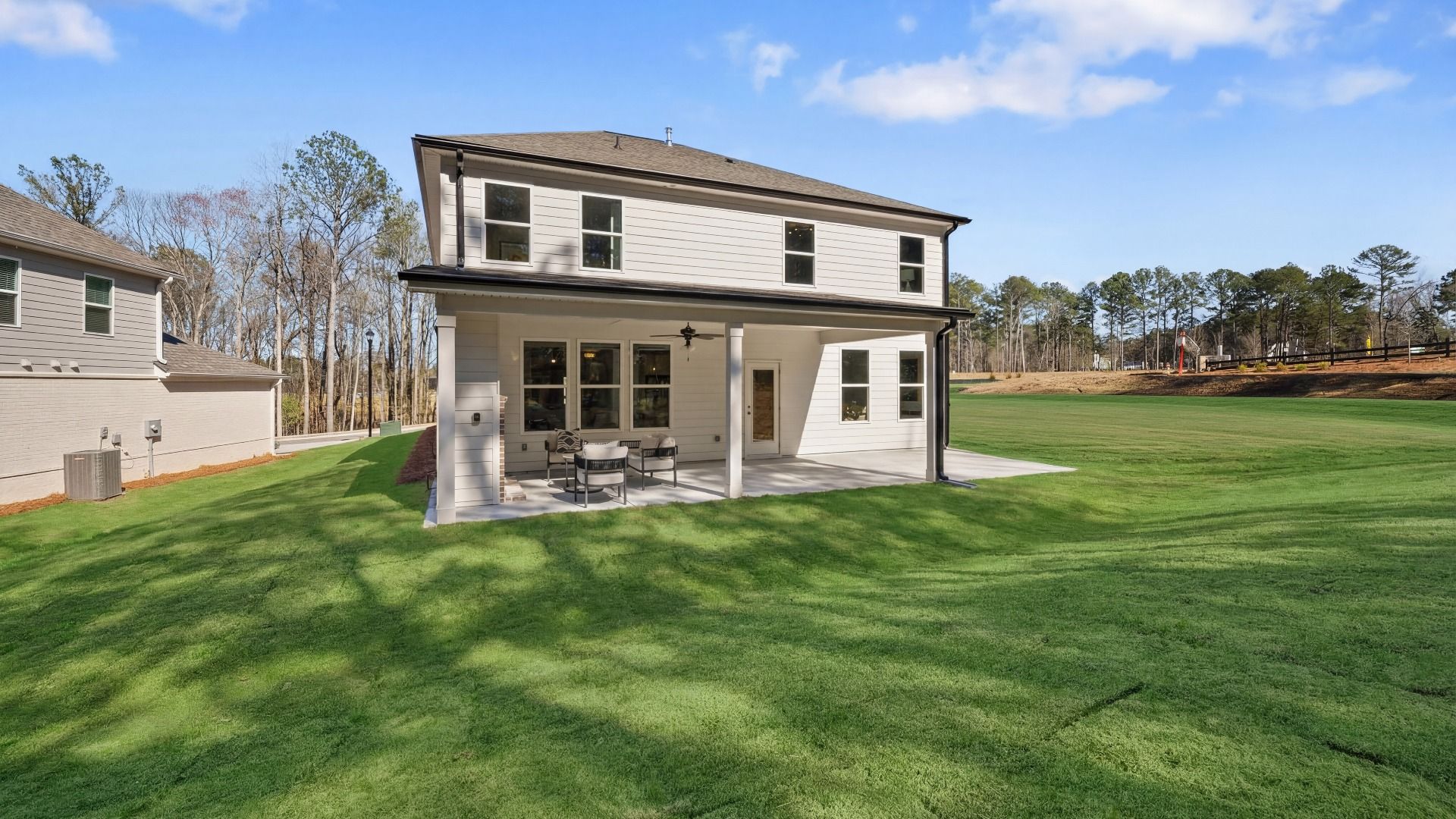 Rear exterior of home with covered patio, ceiling fan, and fireplace