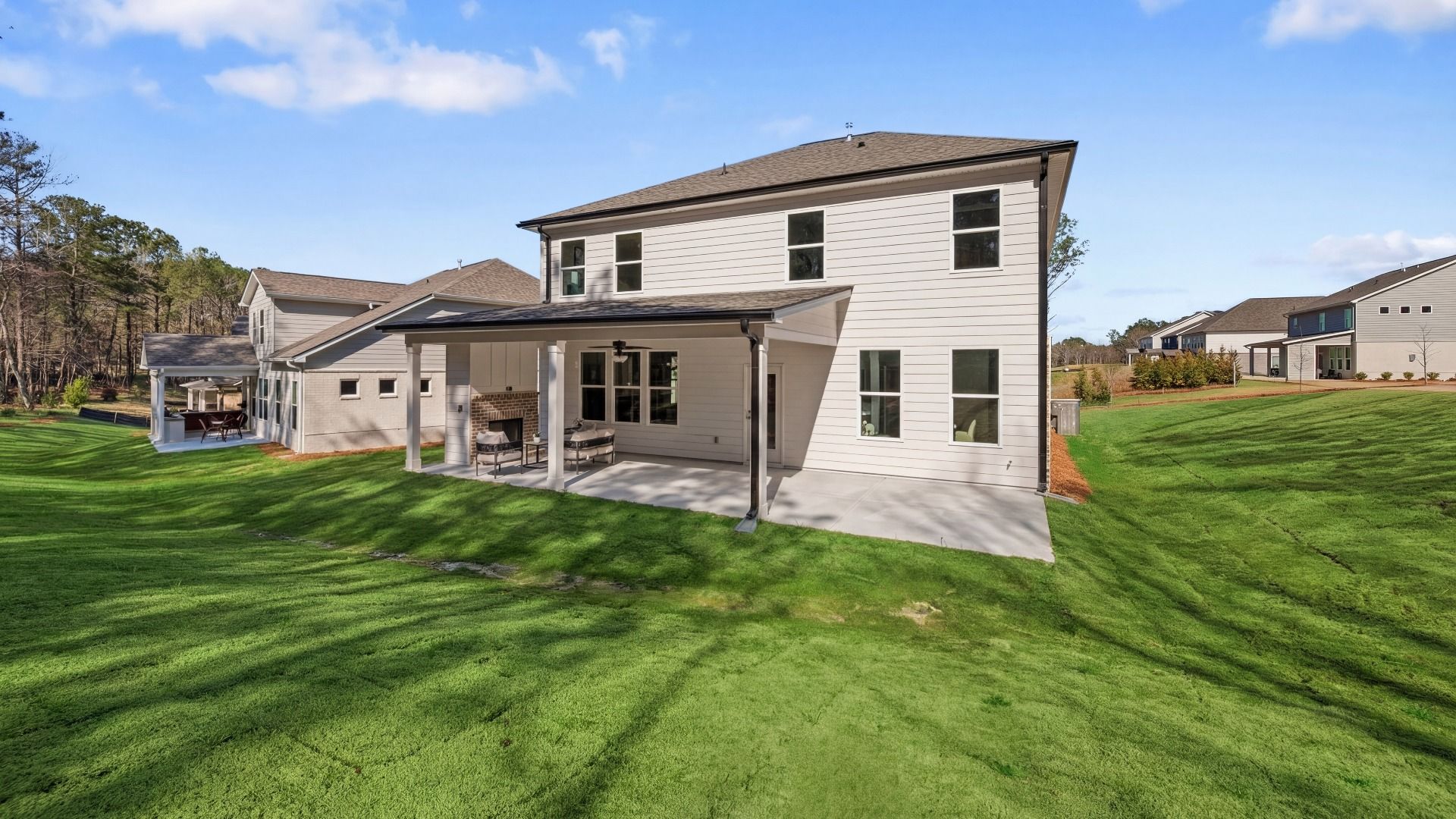 Rear exterior of home with covered patio, ceiling fan, and fireplace