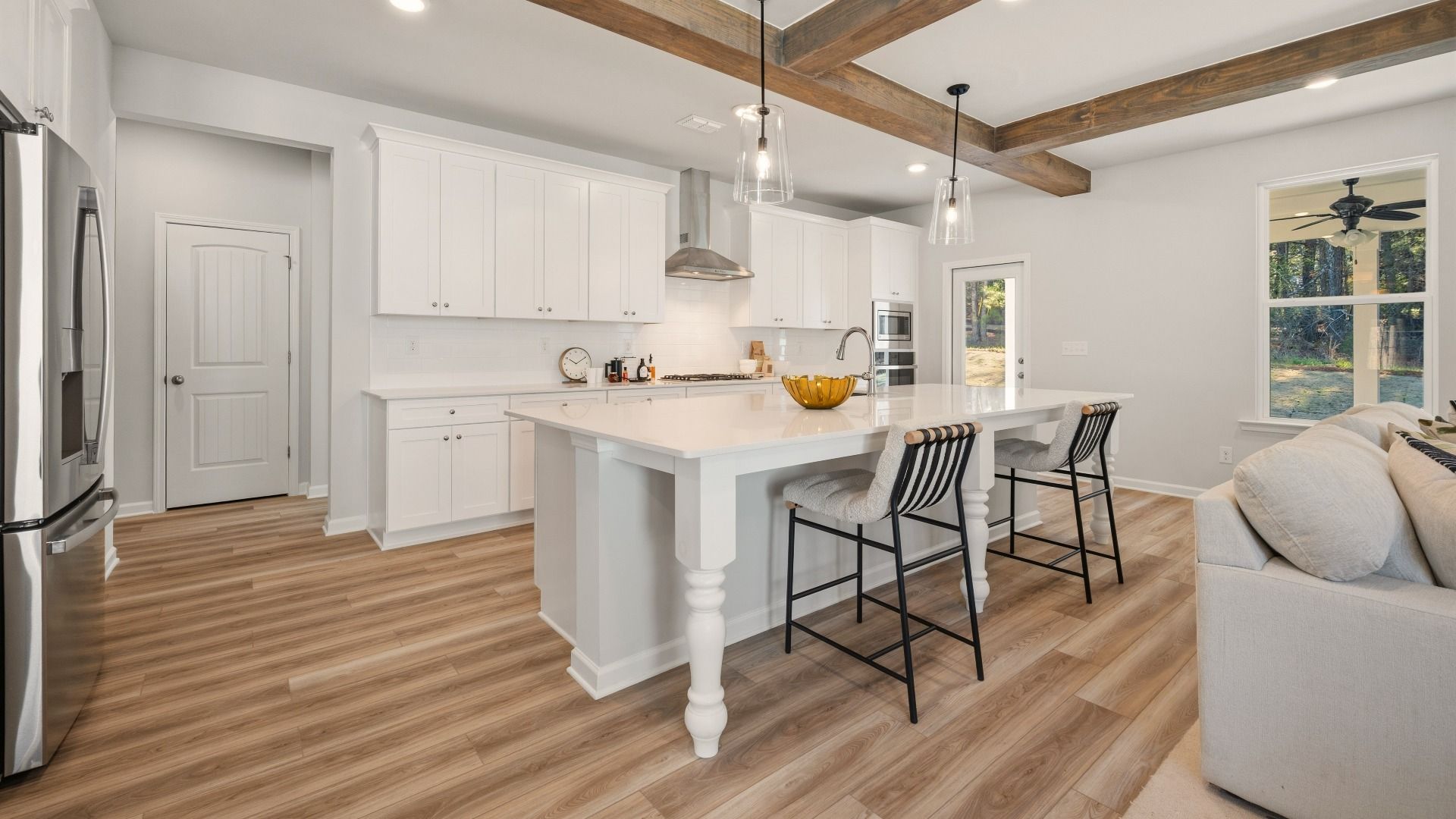 Kitchen with tile backsplash, quartz countertops, and pendant lighting
