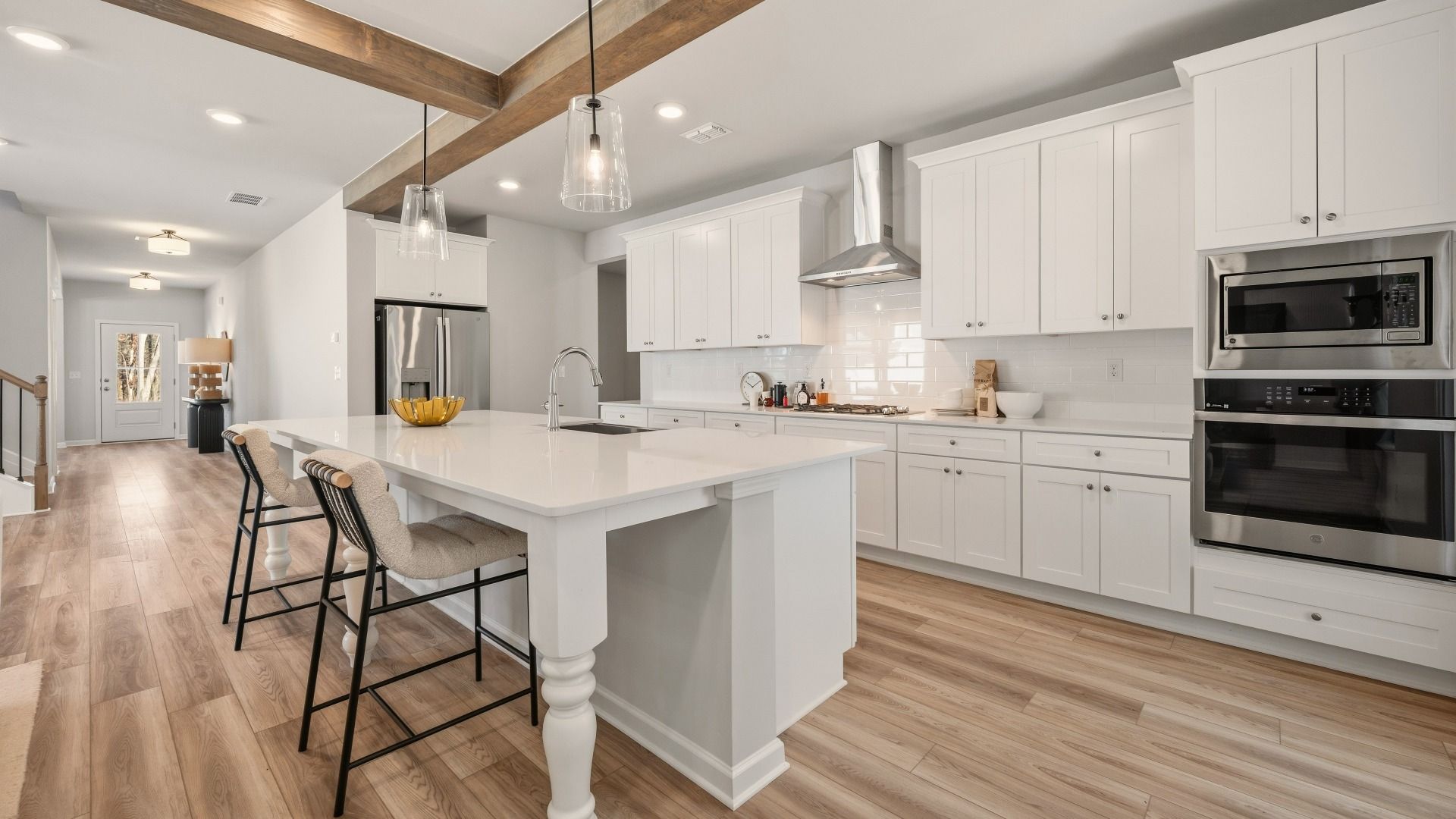 Kitchen with tile backsplash, quartz countertops, and pendant lighting