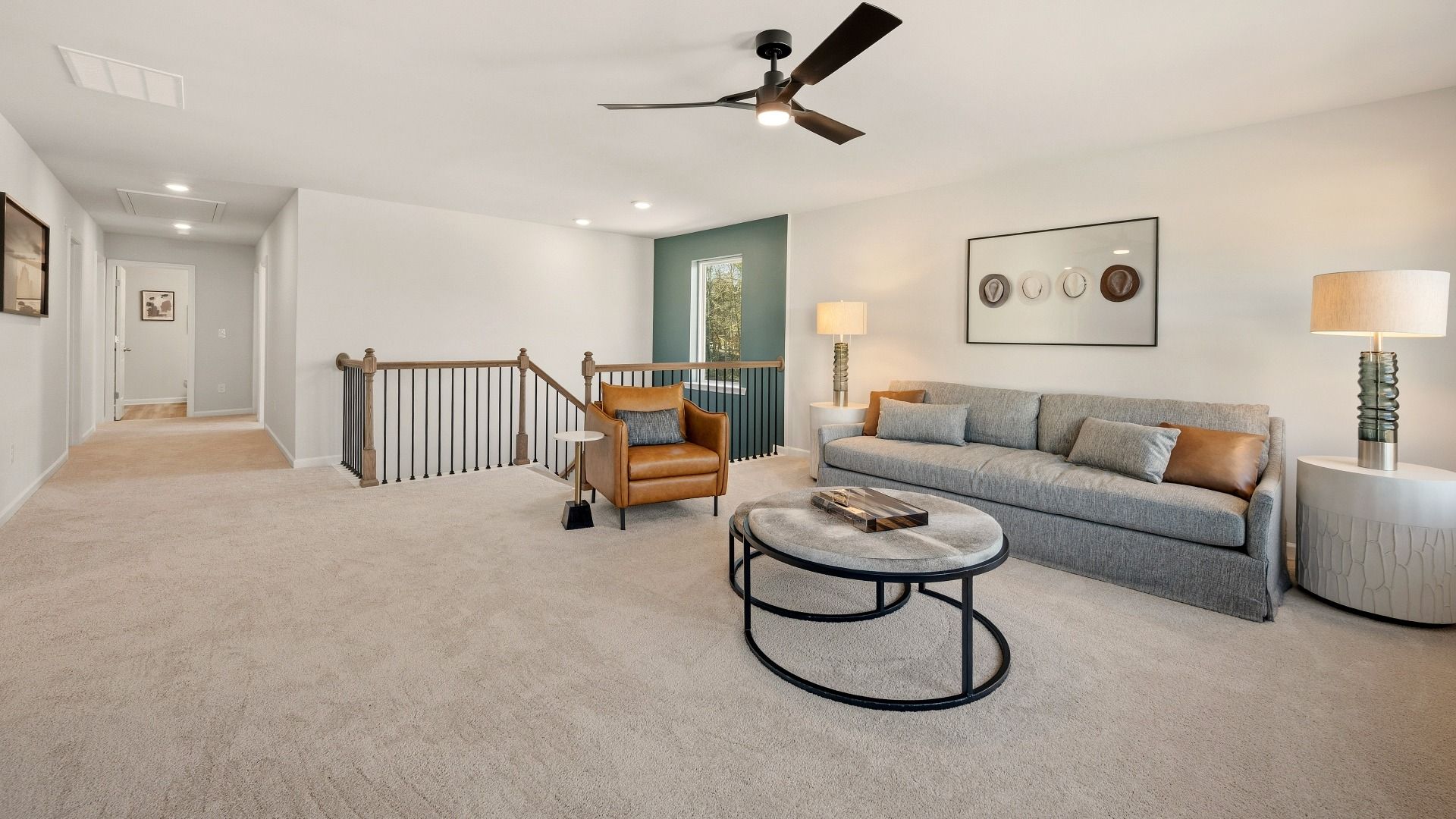 Spacious loft area with ceiling fan and carpet