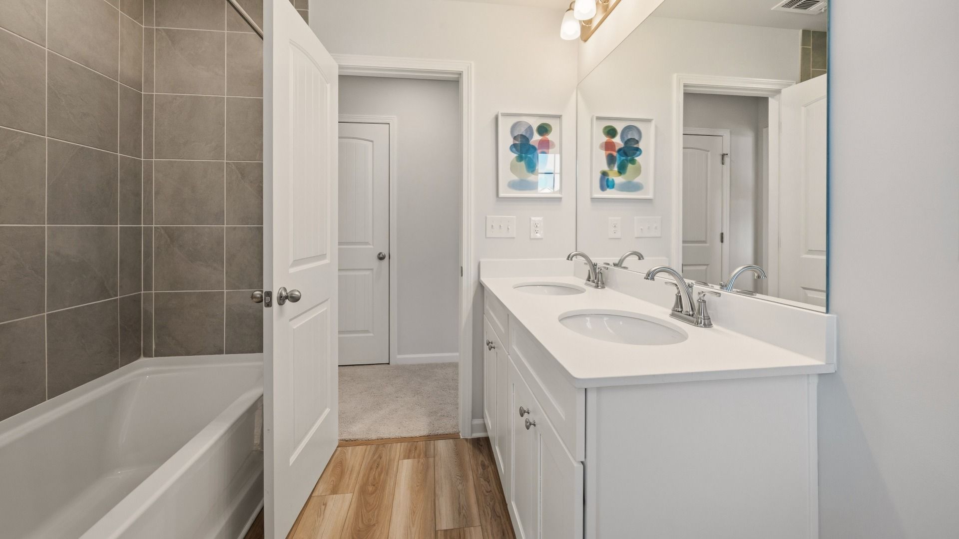 Secondary bathroom with dual vanity and tiled shower