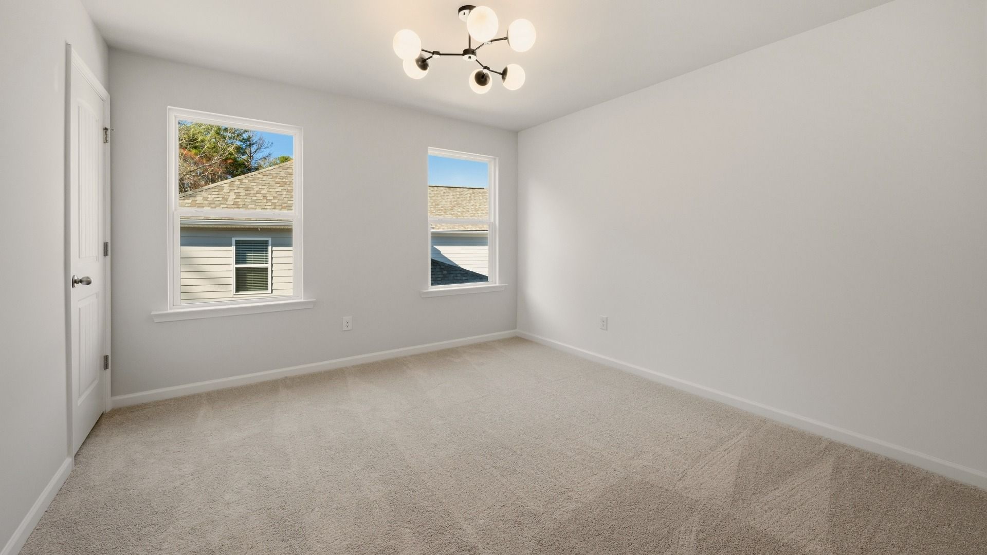 Bedroom with bright natural lighting from windows and carpet