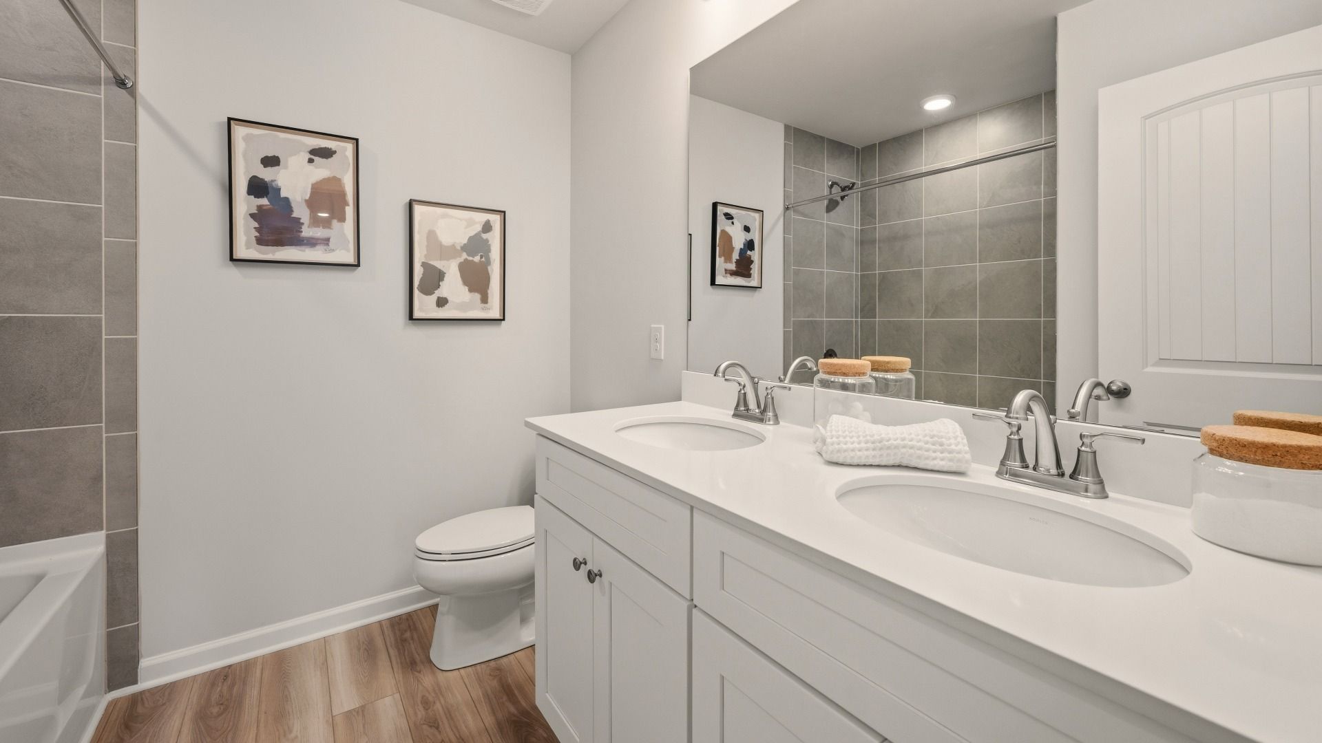 Secondary bathroom with dual vanity and tiled shower