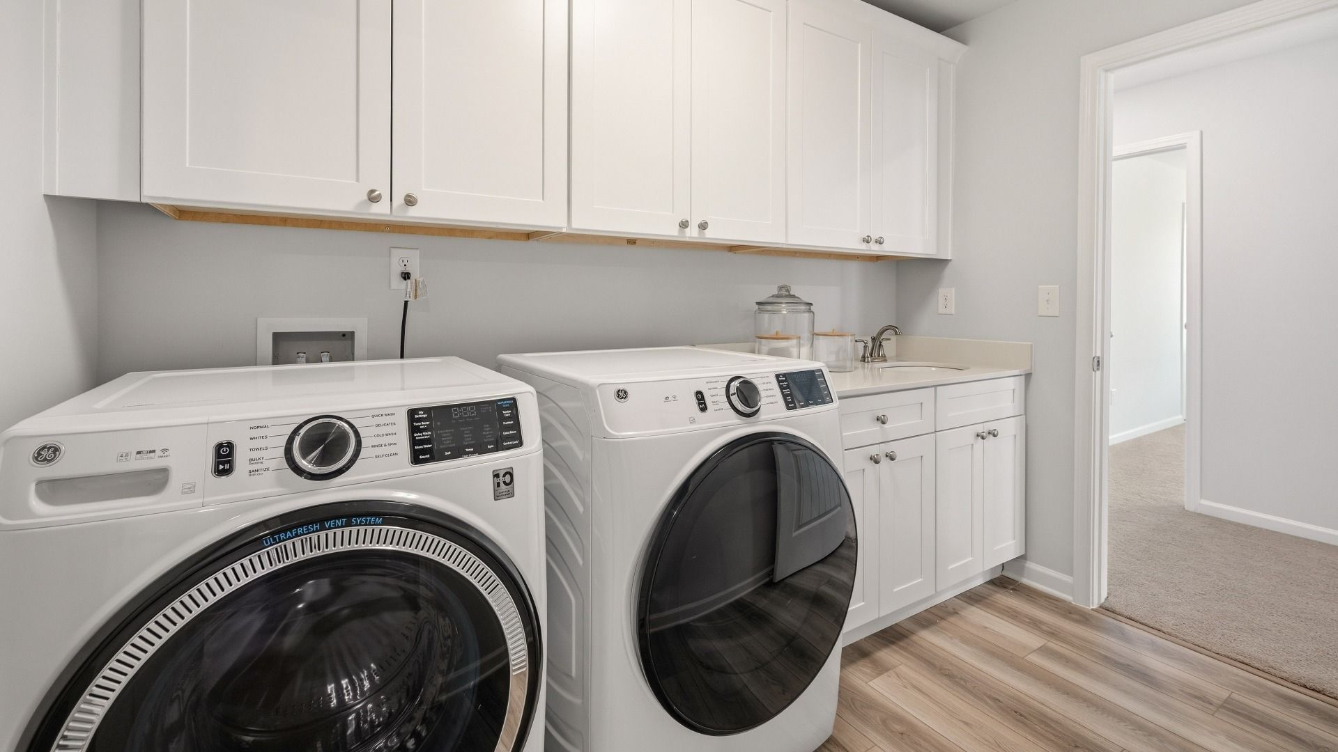 Dedicated laundry room with cabinetry and sink