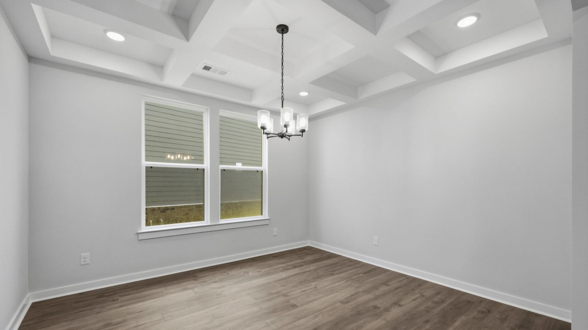 Dedicated laundry area with coffered ceiling and bright natural lighting from windows