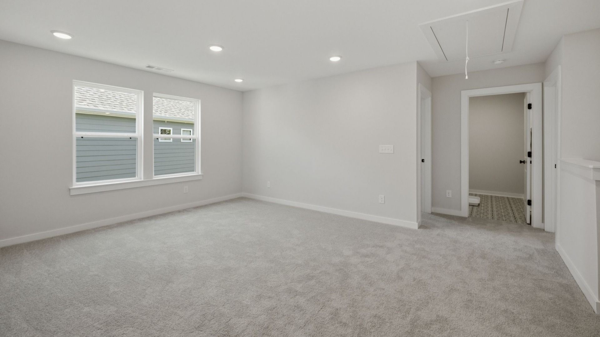 Loft with access to bedrooms with carpet and windows