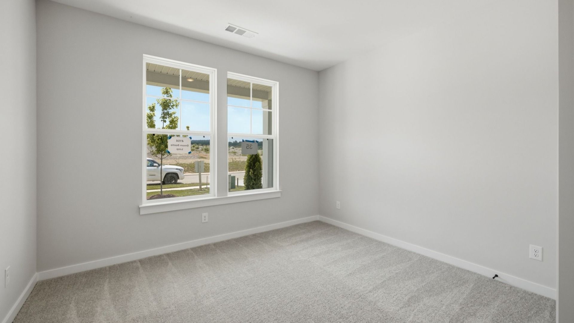 Spacious secondary bedroom with carpet and windows