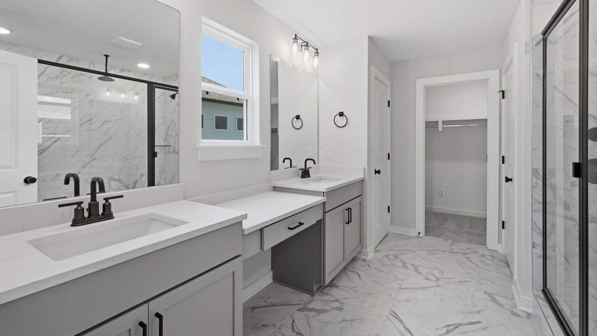 Primary bathroom with dual vanity, glass enclosed shower, and access to closet