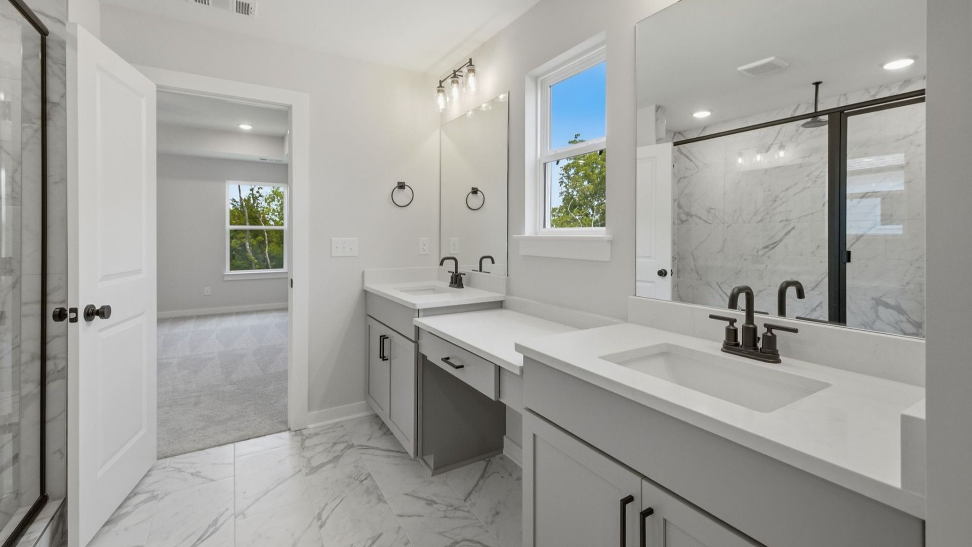 Primary bathroom with dual vanity, glass enclosed shower, and access to suite