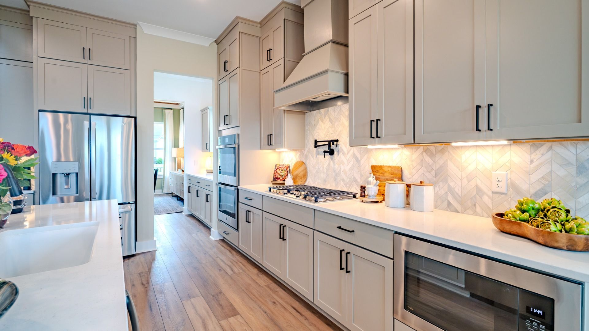Kitchen with tile backsplash, quartz countertops, and pendant lighting