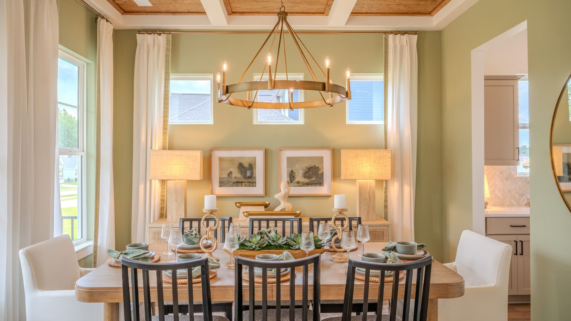 Dining area with coffered ceiling, access to kitchen, and bright natural lighting from windows