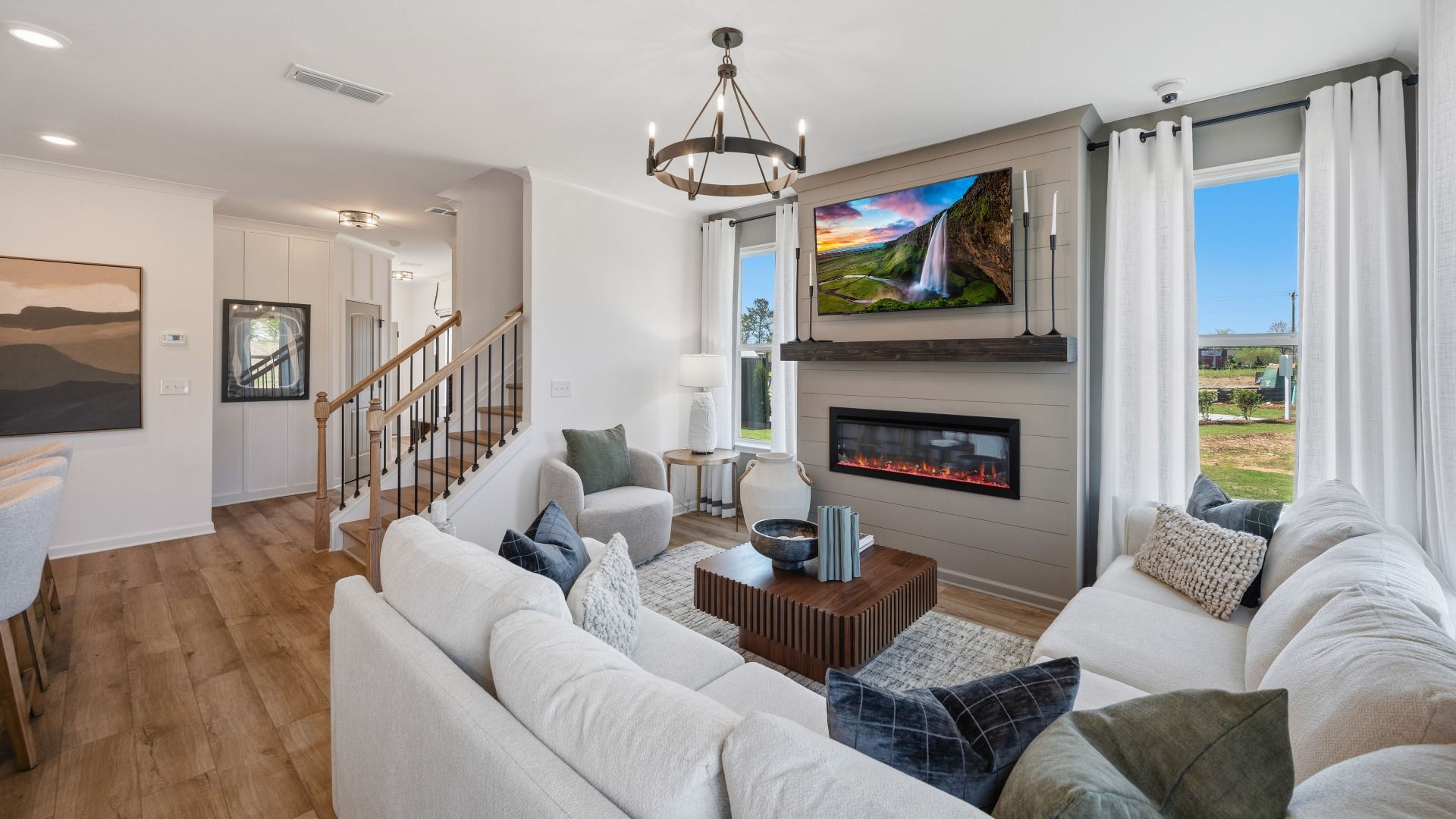 Open concept first floor and living room with electric fireplace, nearby kitchen