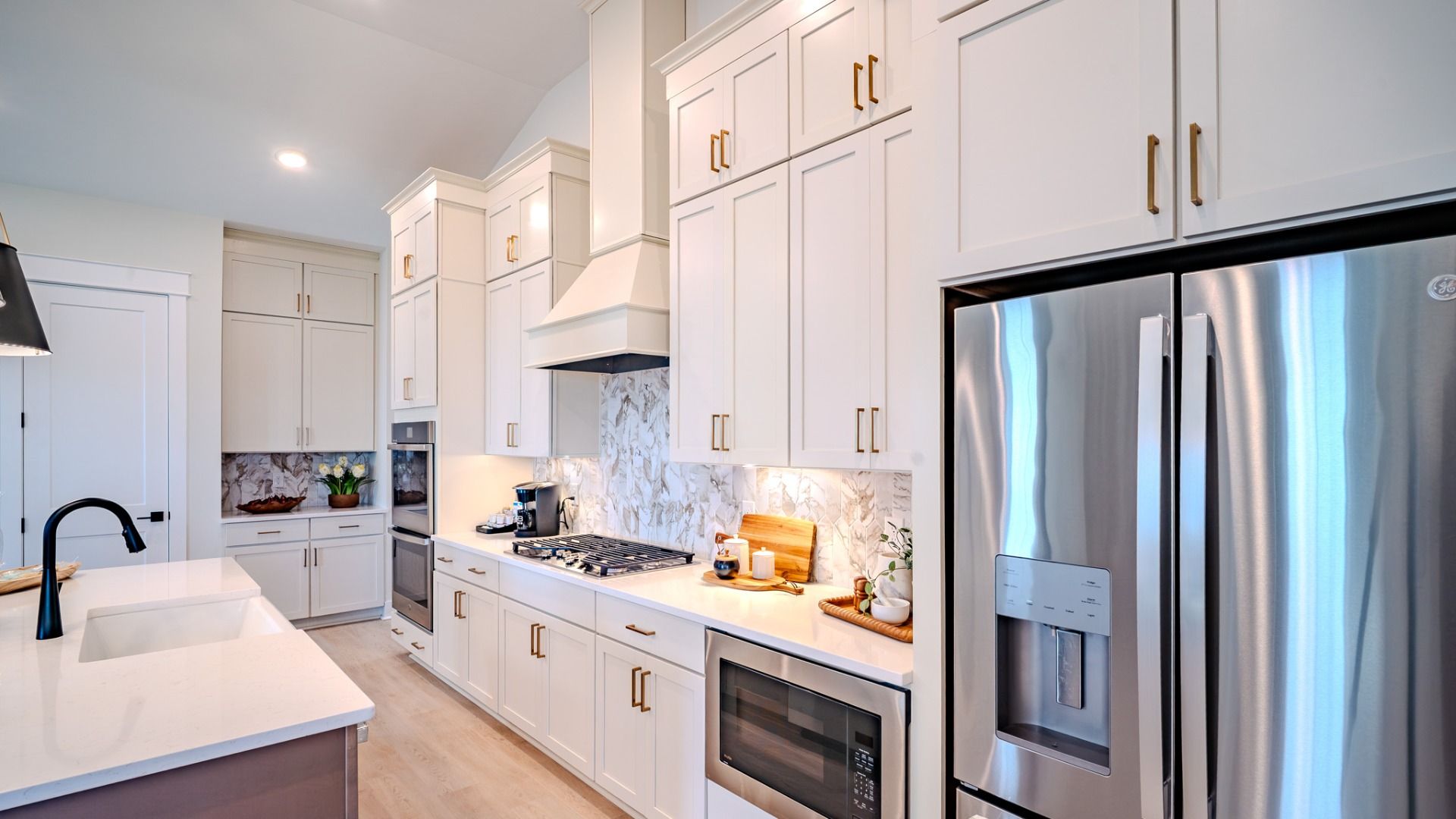 Kitchen with tile backsplash, quartz countertops, and pendant lighting