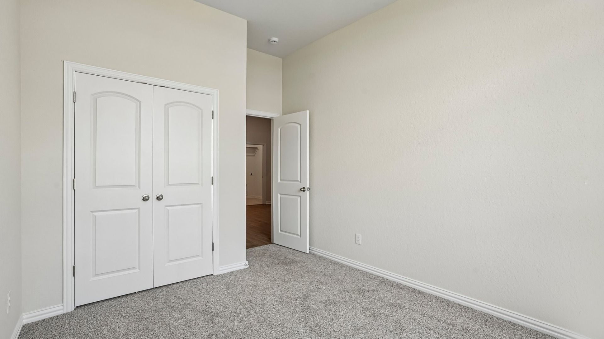 Front bedroom with transom windows and peaceful views of the green space in front of the home.