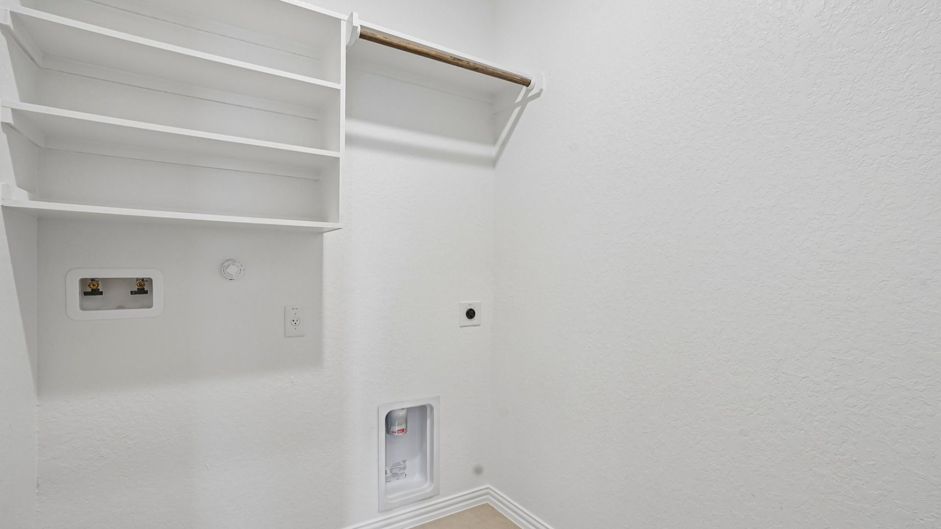 Full-size laundry room with built-in shelving and a clothing rod for added storage and convenience.
