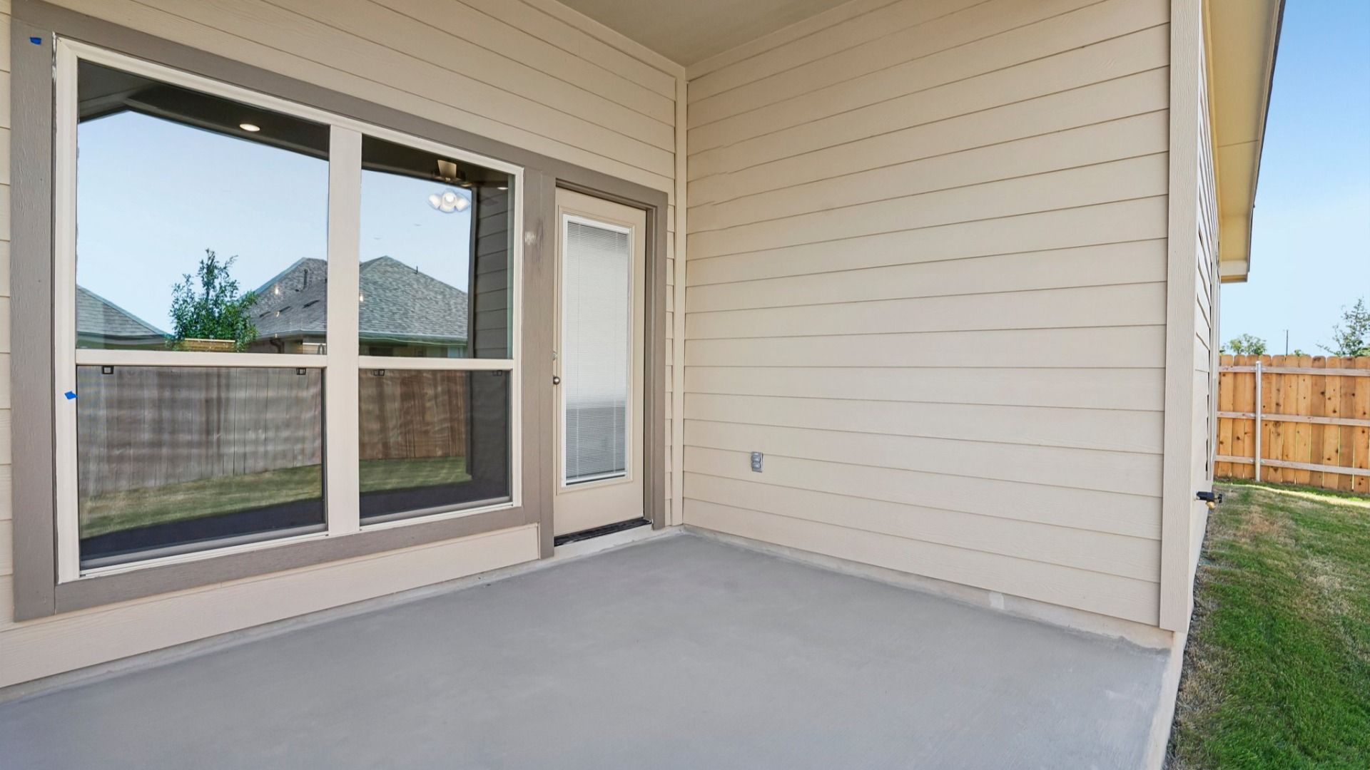 Covered patio overlooking the backyard, creating a comfortable outdoor space for relaxing and entertaining.