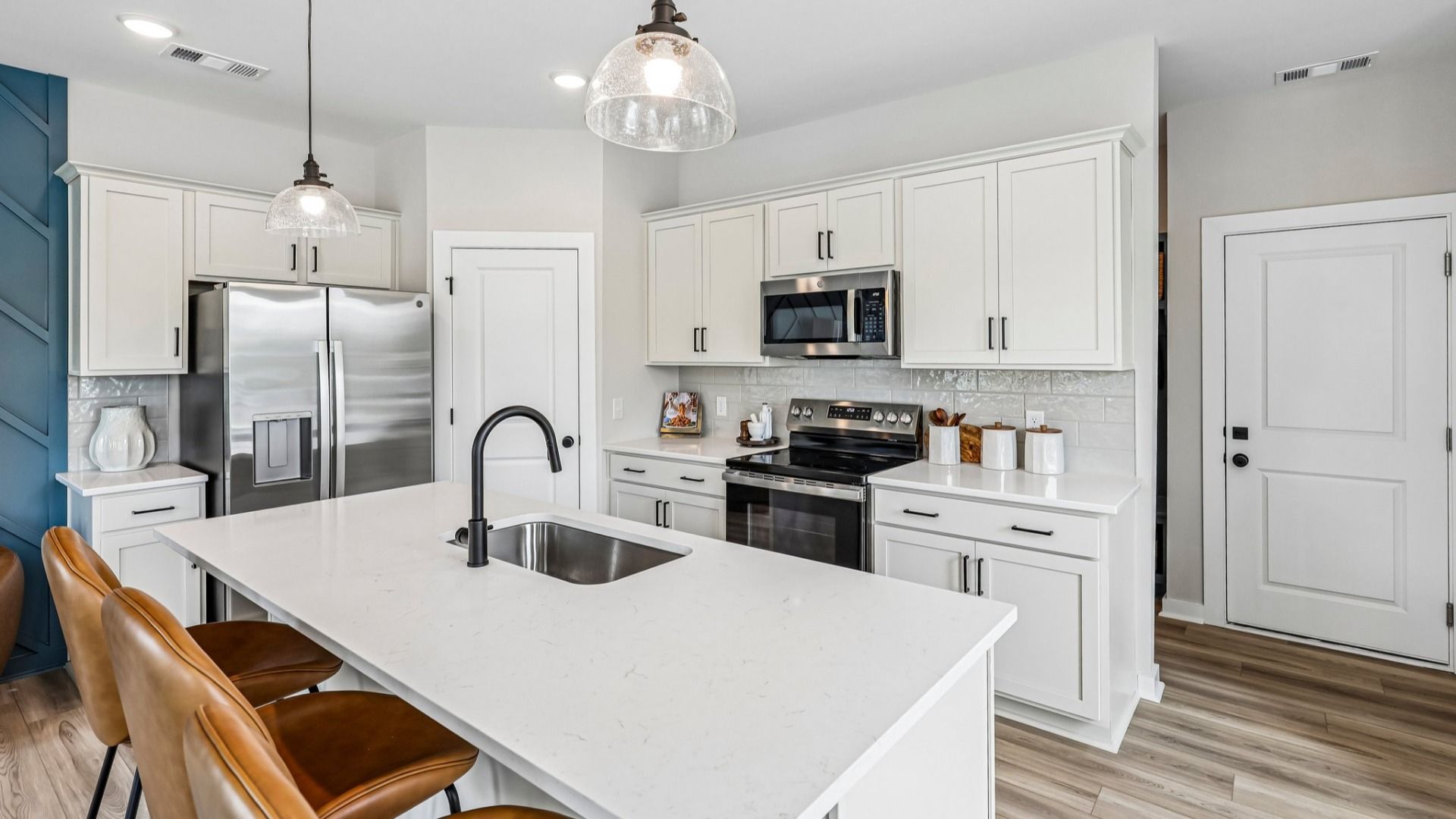 View of kitchen with quartz countertops, tile backsplash, and pendant lighting