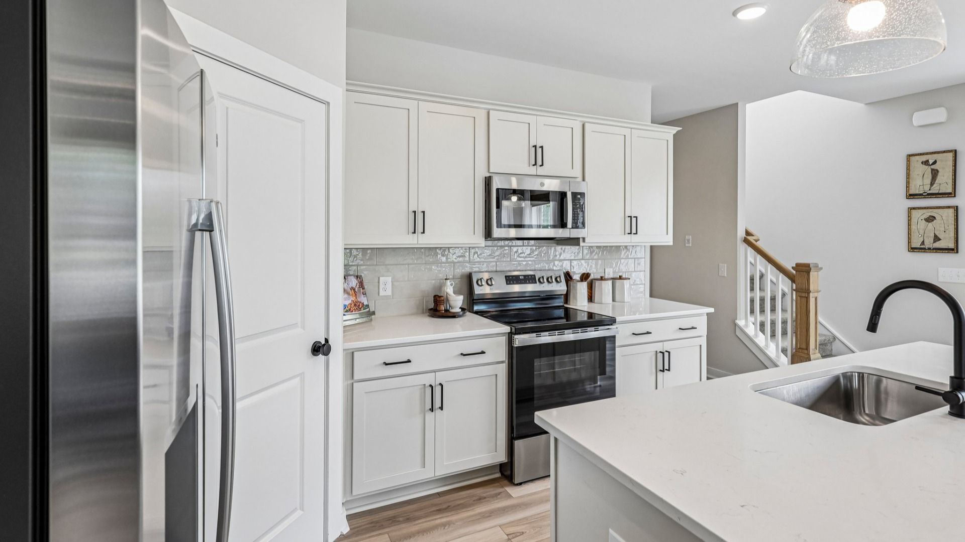 View of kitchen with quartz countertops, tile backsplash, and pendant lighting