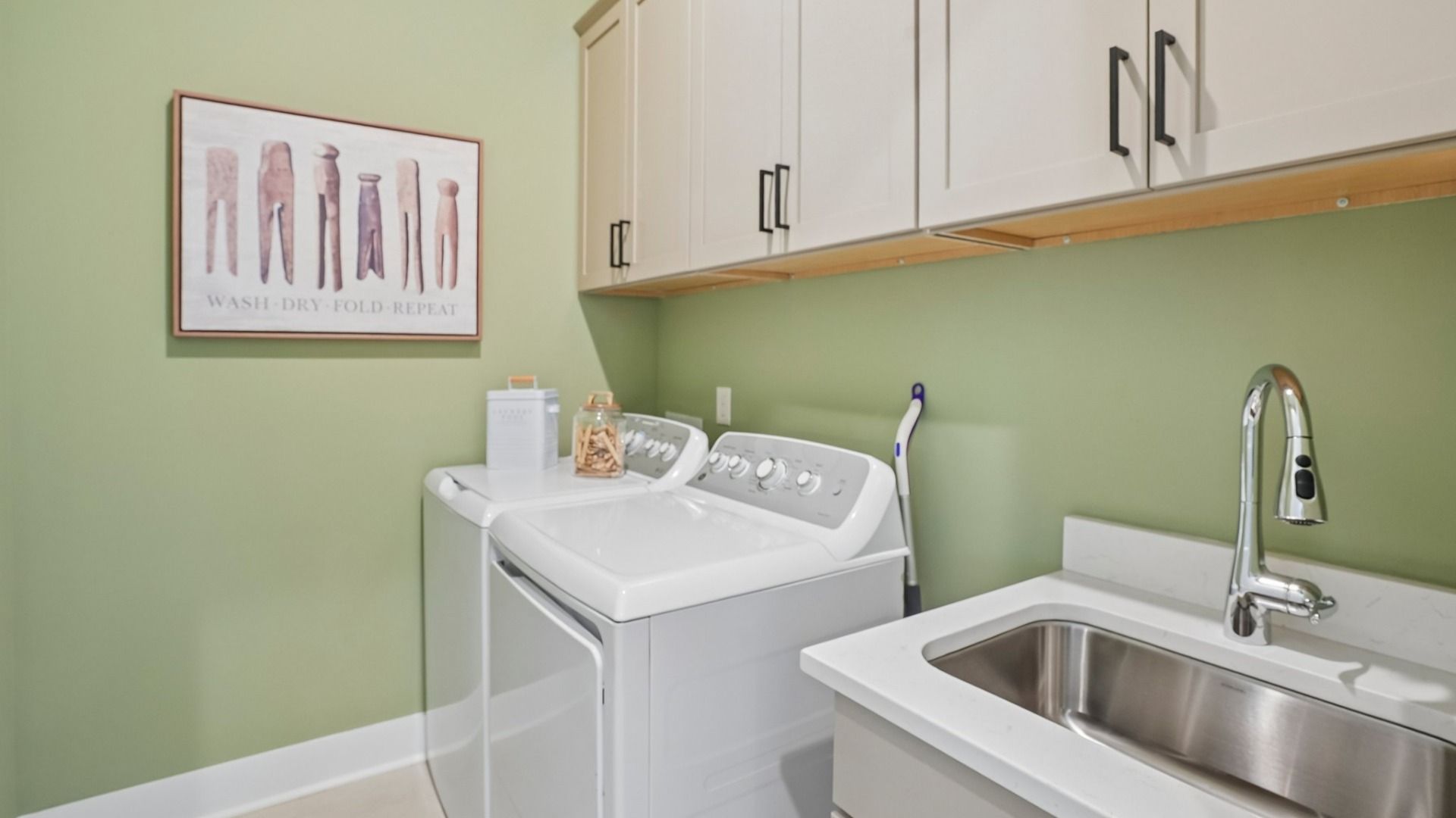 Dedicated laundry room with cabinets and sink
