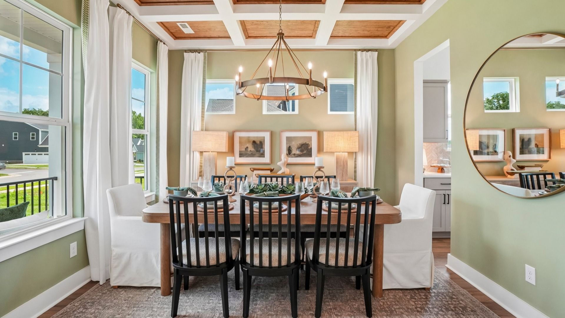 Dedicated dining area with coffered ceiling, natural lighting from windows, and access to kitchen