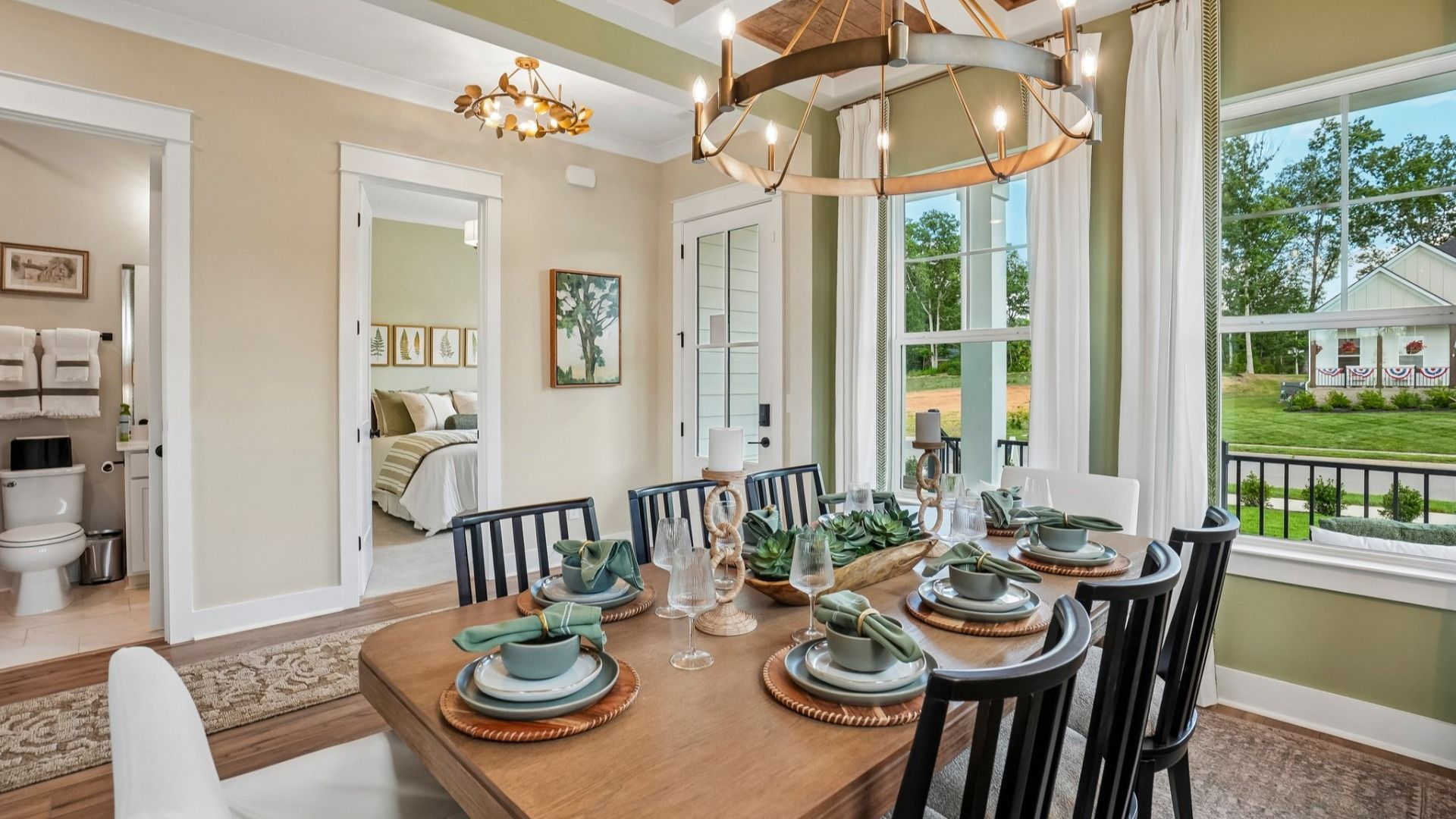 Dedicated dining area with coffered ceiling, natural lighting from windows, and access to front entry