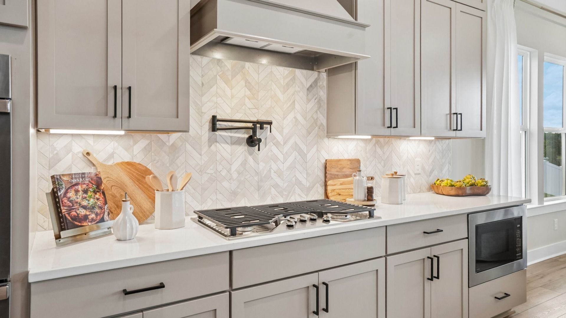 View of kitchen with quartz countertops, tile backsplash, and gas stove-top