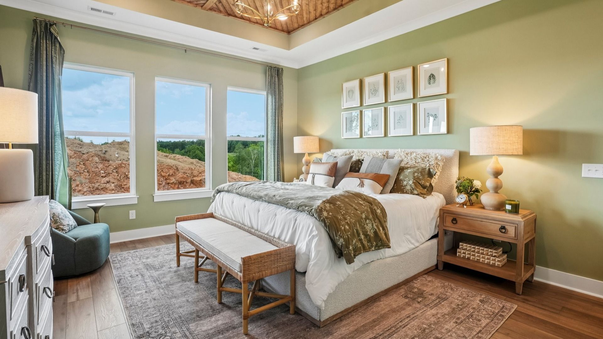 Primary suite with tray ceiling, windows, and hard surface flooring