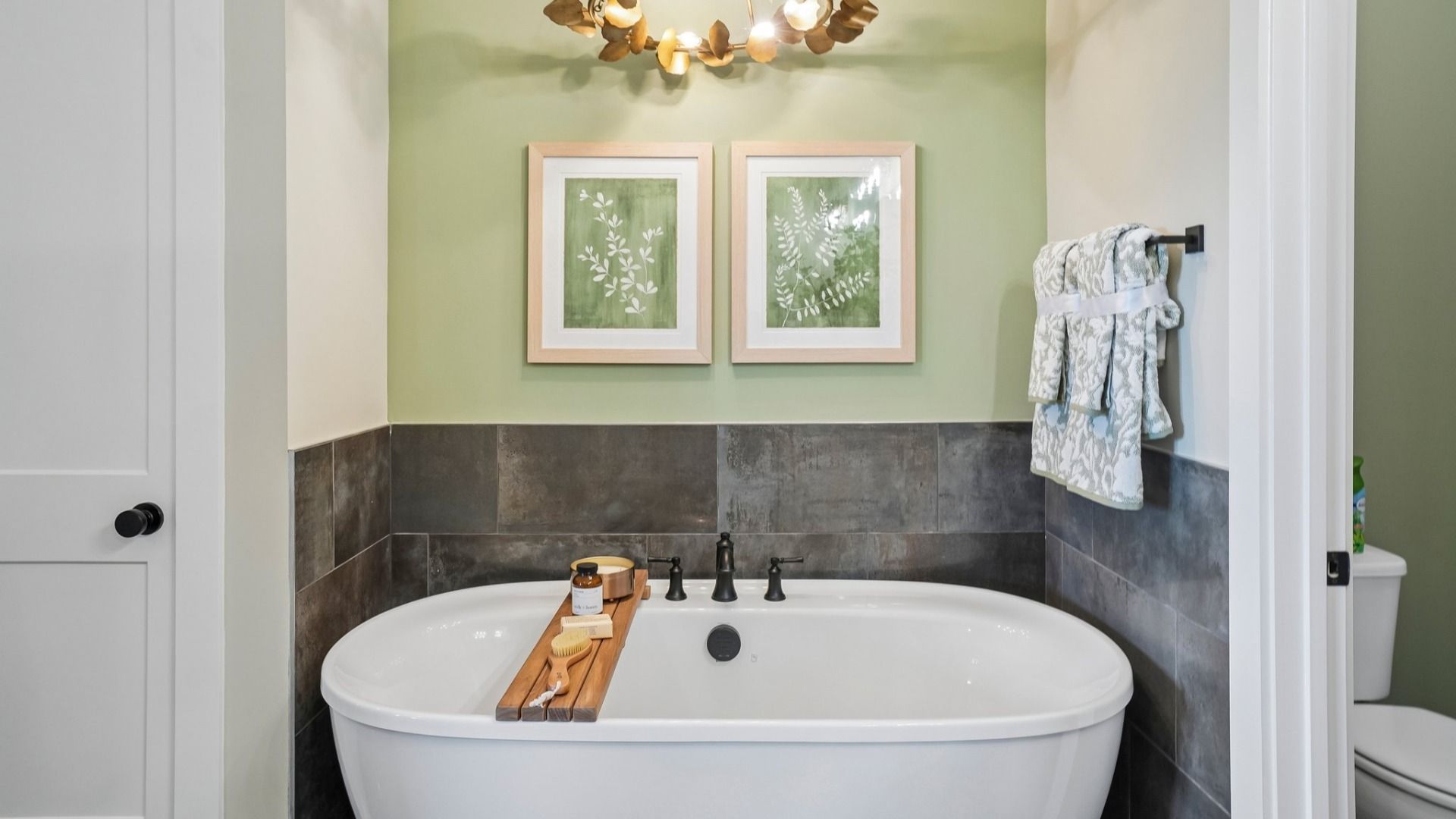 Primary bathroom with soaking tub and lighting fixture